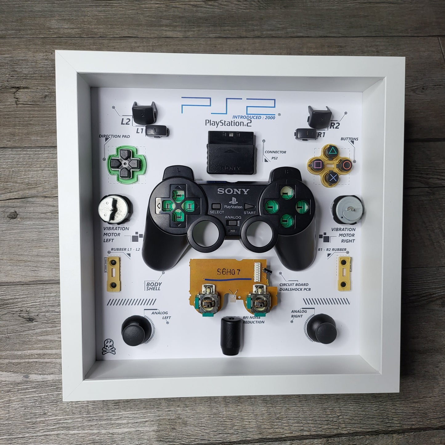 Shadow Box 10x10 with wood frame and polycarbonate glass for wall and Tabletop containing a disassembled controller for Playstation and Nintendo
