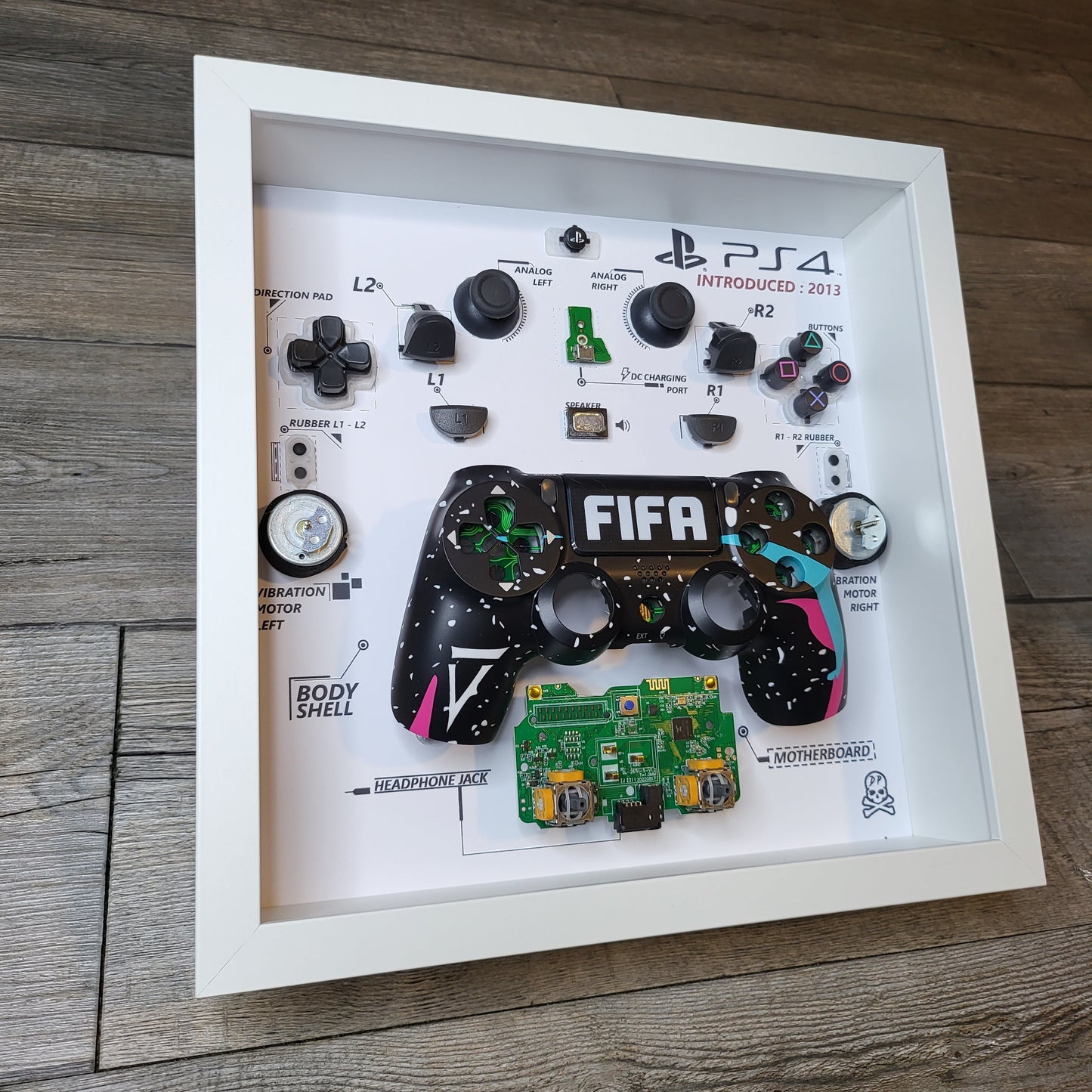 Shadow Box 10x10 with wood frame and polycarbonate glass for wall and Tabletop containing a disassembled controller for Playstation and Nintendo