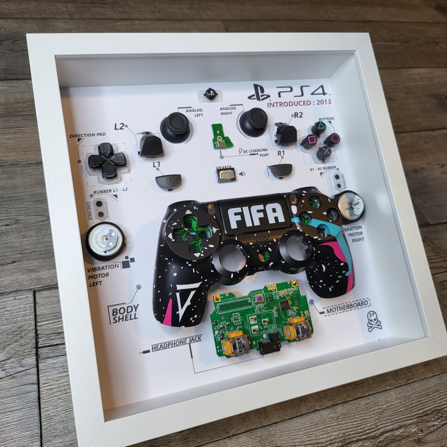 Shadow Box 10x10 with wood frame and polycarbonate glass for wall and Tabletop containing a disassembled controller for Playstation and Nintendo