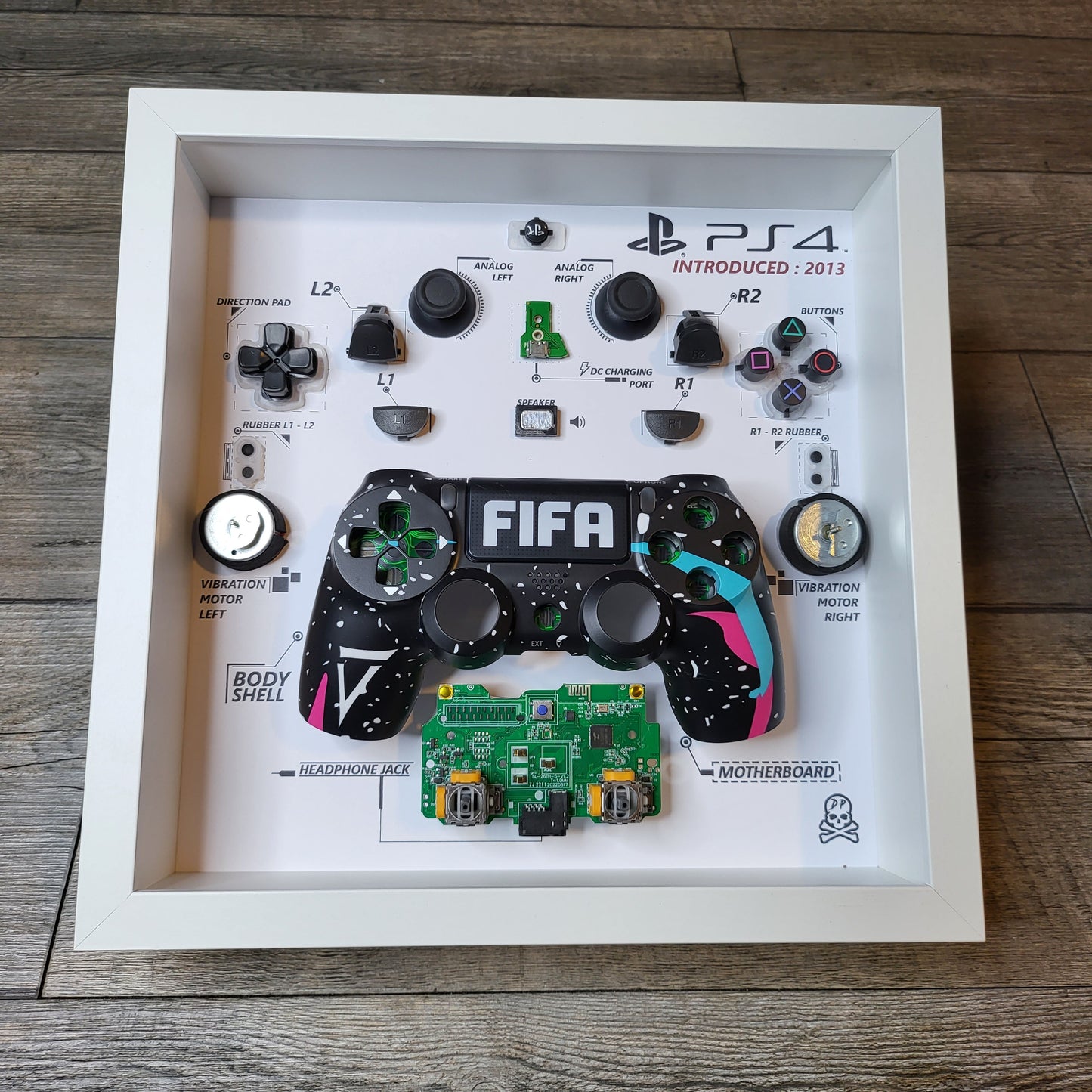 Shadow Box 10x10 with wood frame and polycarbonate glass for wall and Tabletop containing a disassembled controller for Playstation and Nintendo