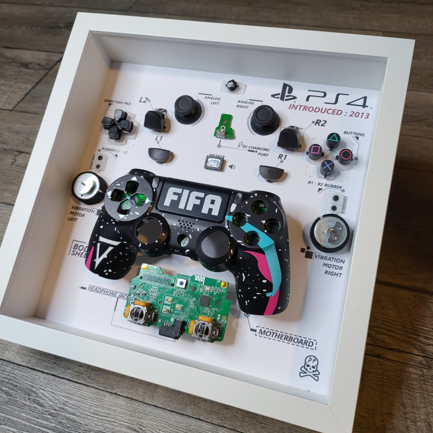 Shadow Box 10x10 with wood frame and polycarbonate glass for wall and Tabletop containing a disassembled controller for Playstation and Nintendo