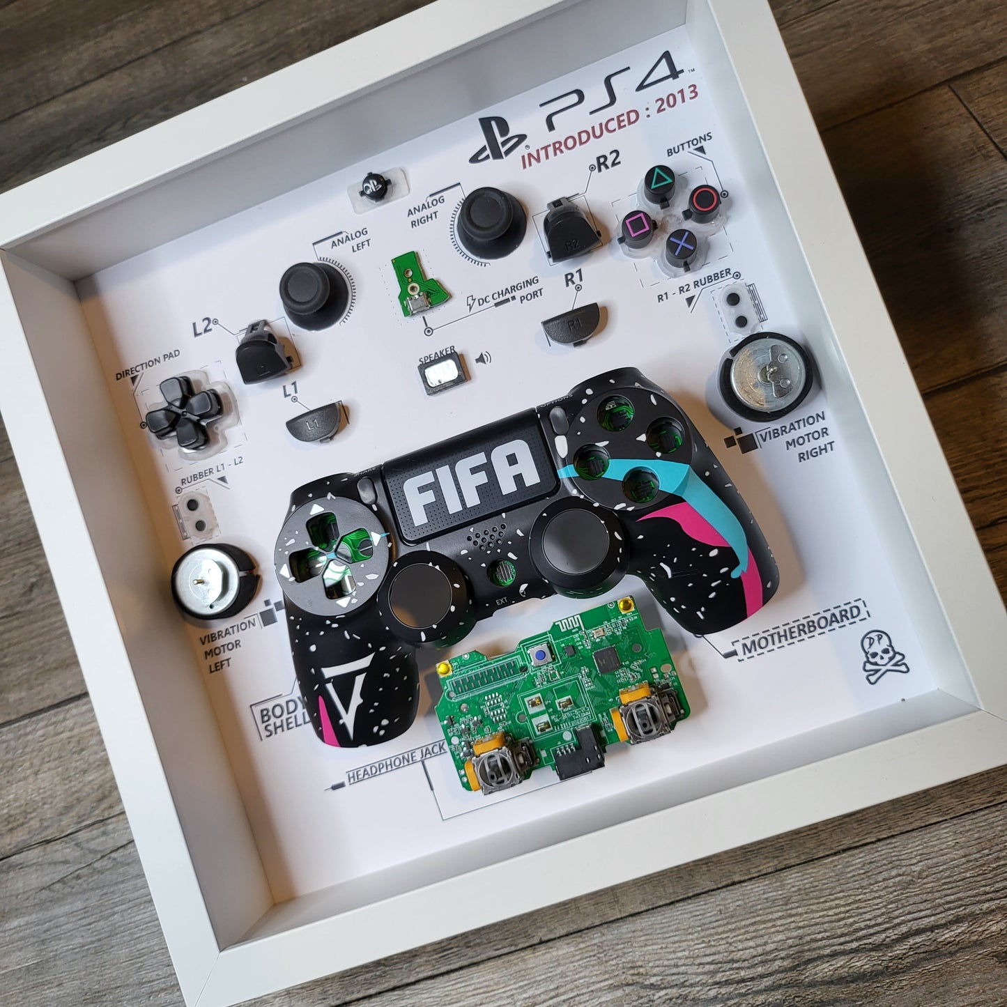 Shadow Box 10x10 with wood frame and polycarbonate glass for wall and Tabletop containing a disassembled controller for Playstation and Nintendo