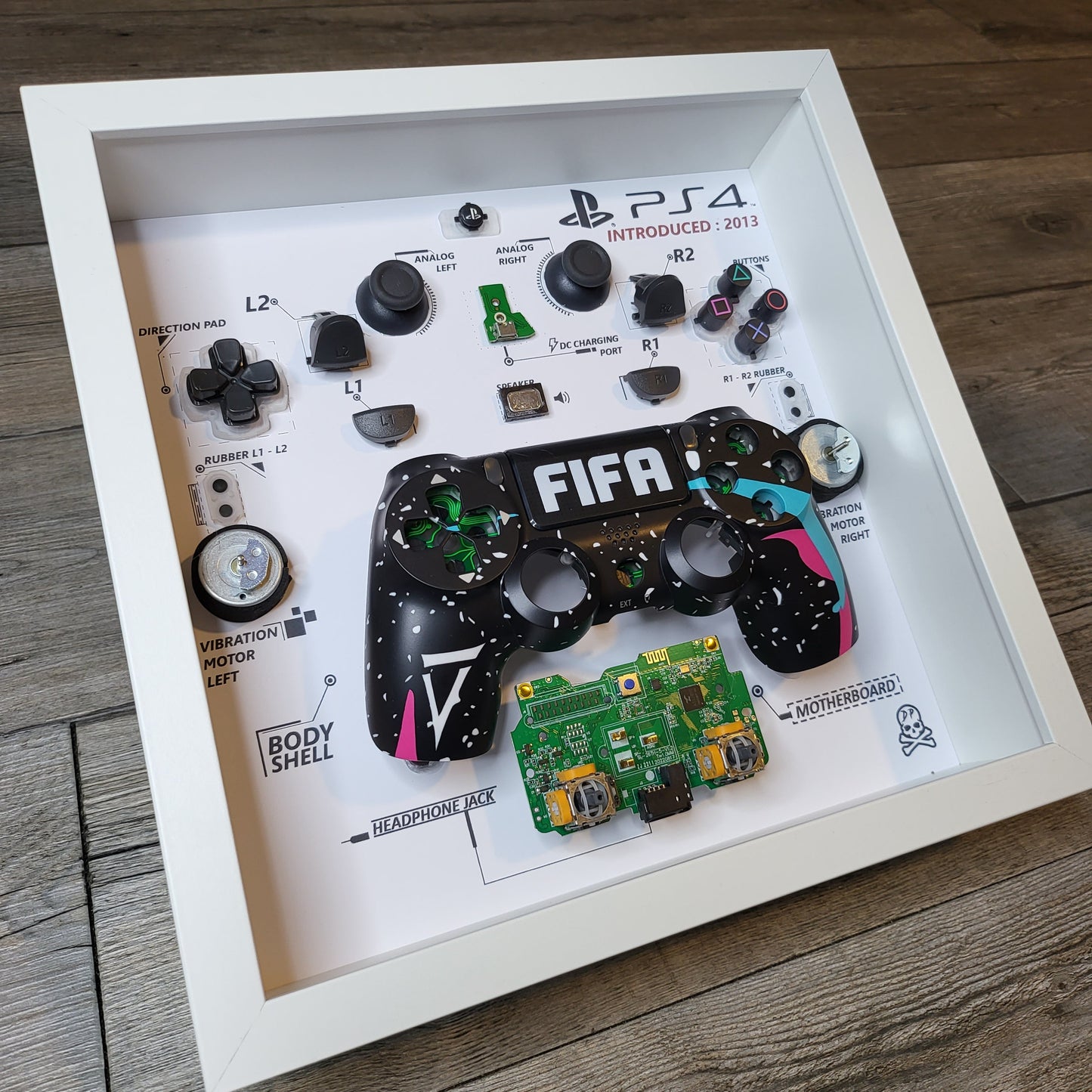 Shadow Box 10x10 with wood frame and polycarbonate glass for wall and Tabletop containing a disassembled controller for Playstation and Nintendo