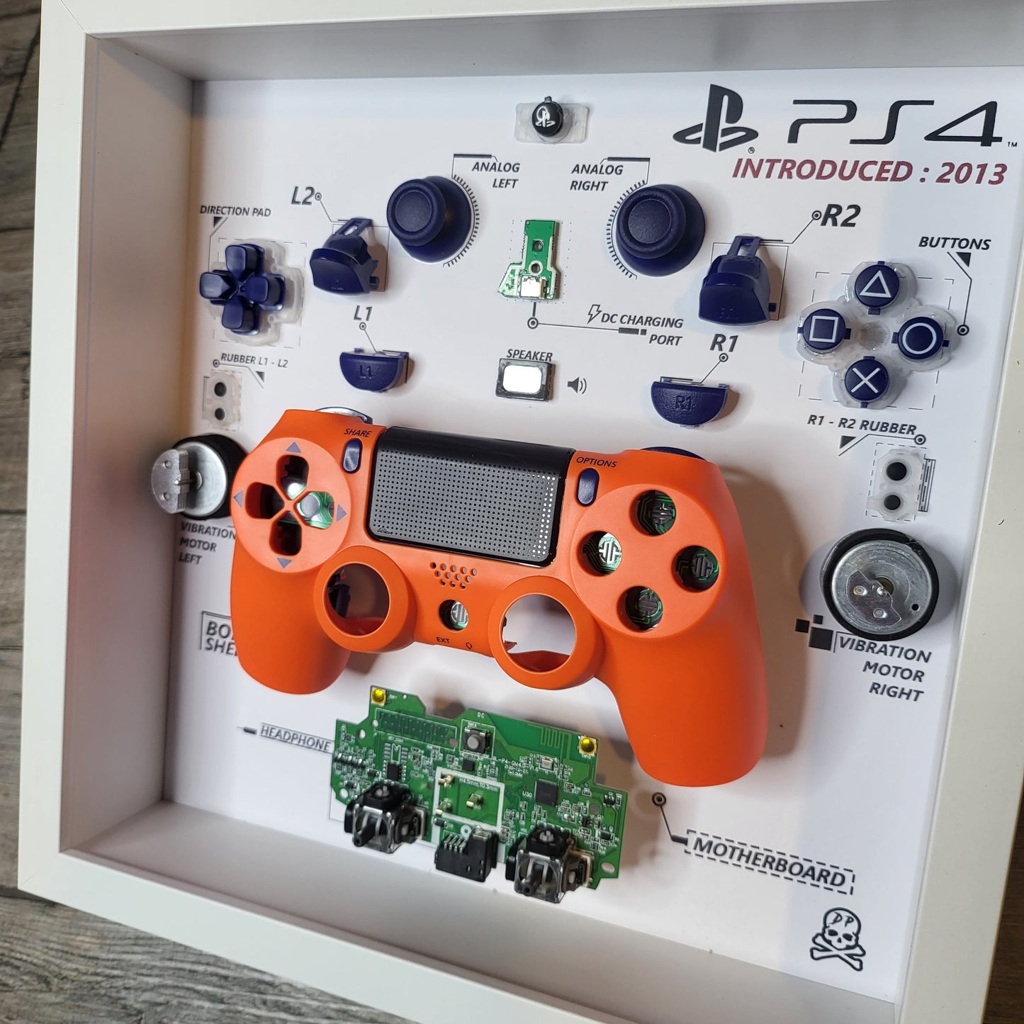 Shadow Box 10x10 with wood frame and polycarbonate glass for wall and Tabletop containing a disassembled controller for Playstation and Nintendo
