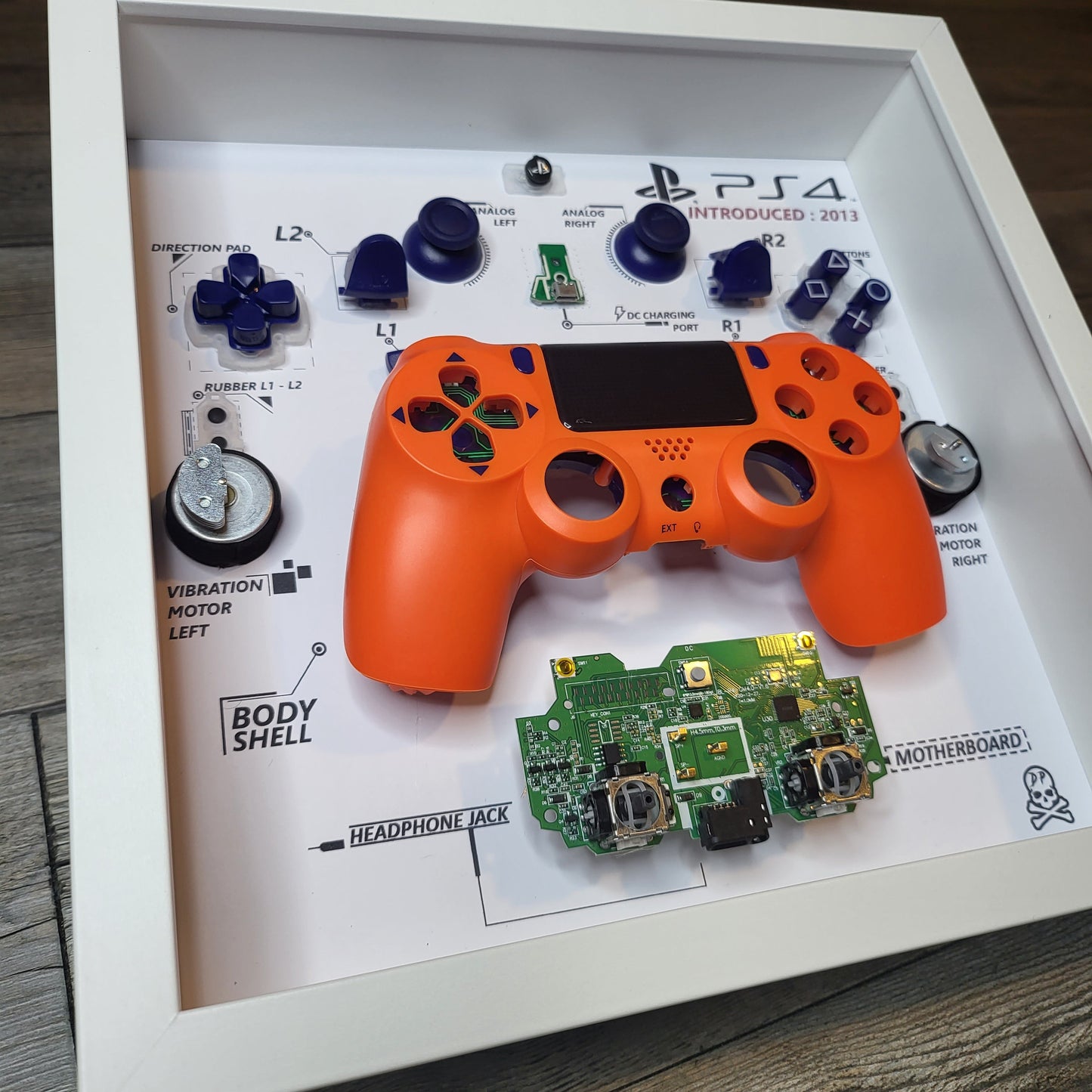 Shadow Box 10x10 with wood frame and polycarbonate glass for wall and Tabletop containing a disassembled controller for Playstation and Nintendo