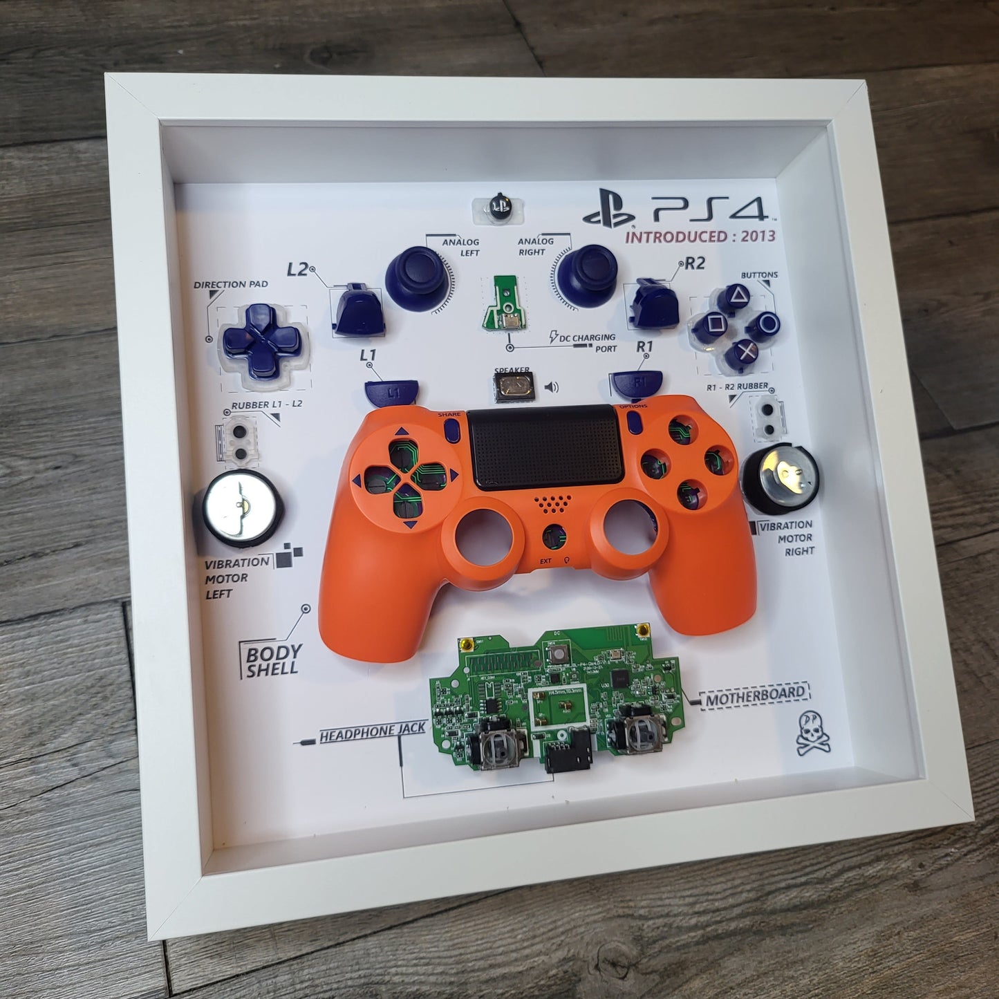 Shadow Box 10x10 with wood frame and polycarbonate glass for wall and Tabletop containing a disassembled controller for Playstation and Nintendo