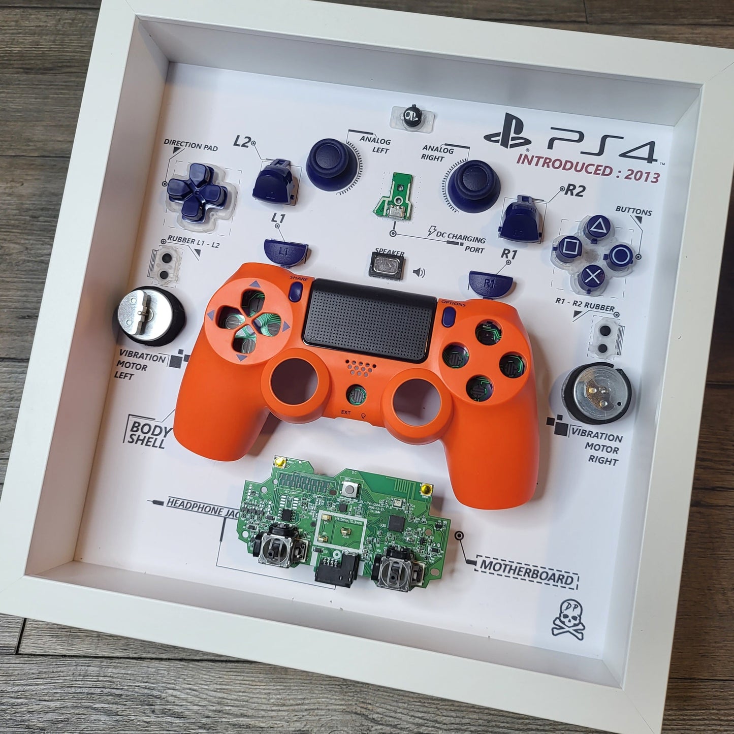 Shadow Box 10x10 with wood frame and polycarbonate glass for wall and Tabletop containing a disassembled controller for Playstation and Nintendo