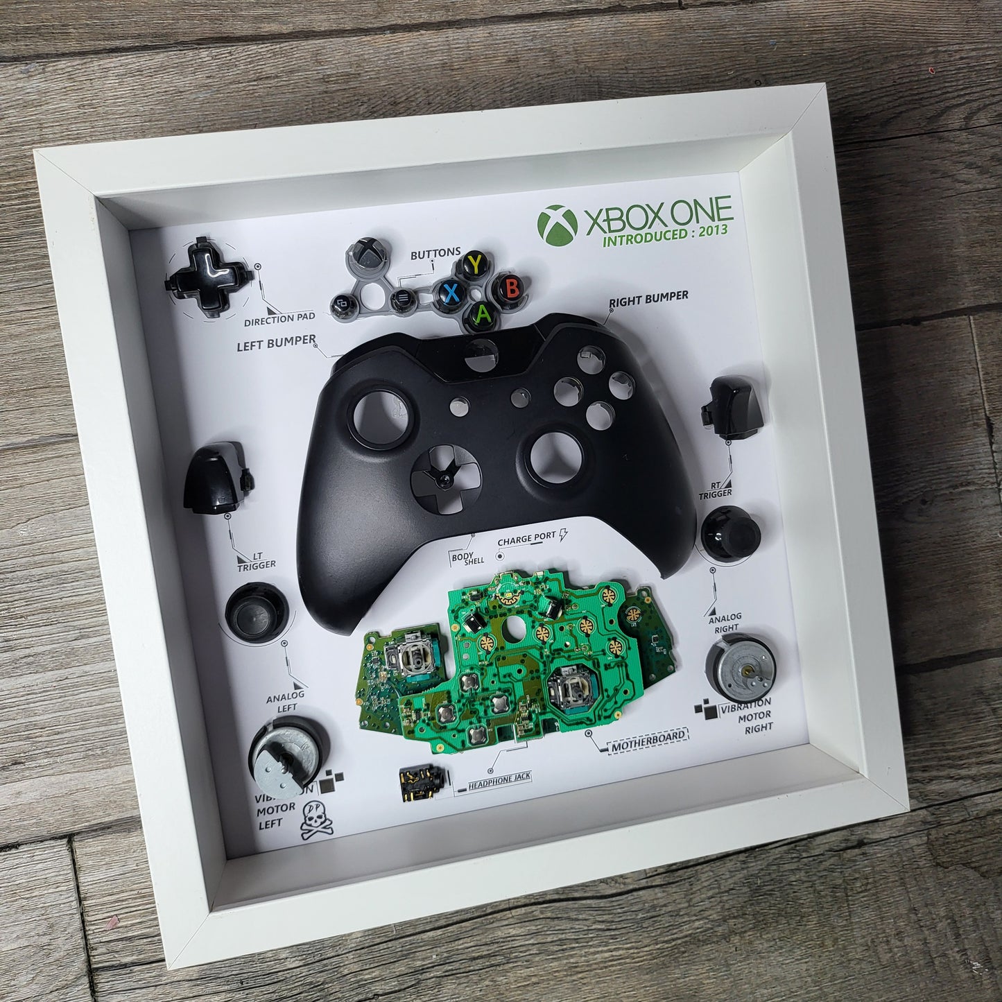Shadow Box 10x10 with wood frame and polycarbonate glass for wall and Tabletop containing a disassembled controller for Playstation and Nintendo