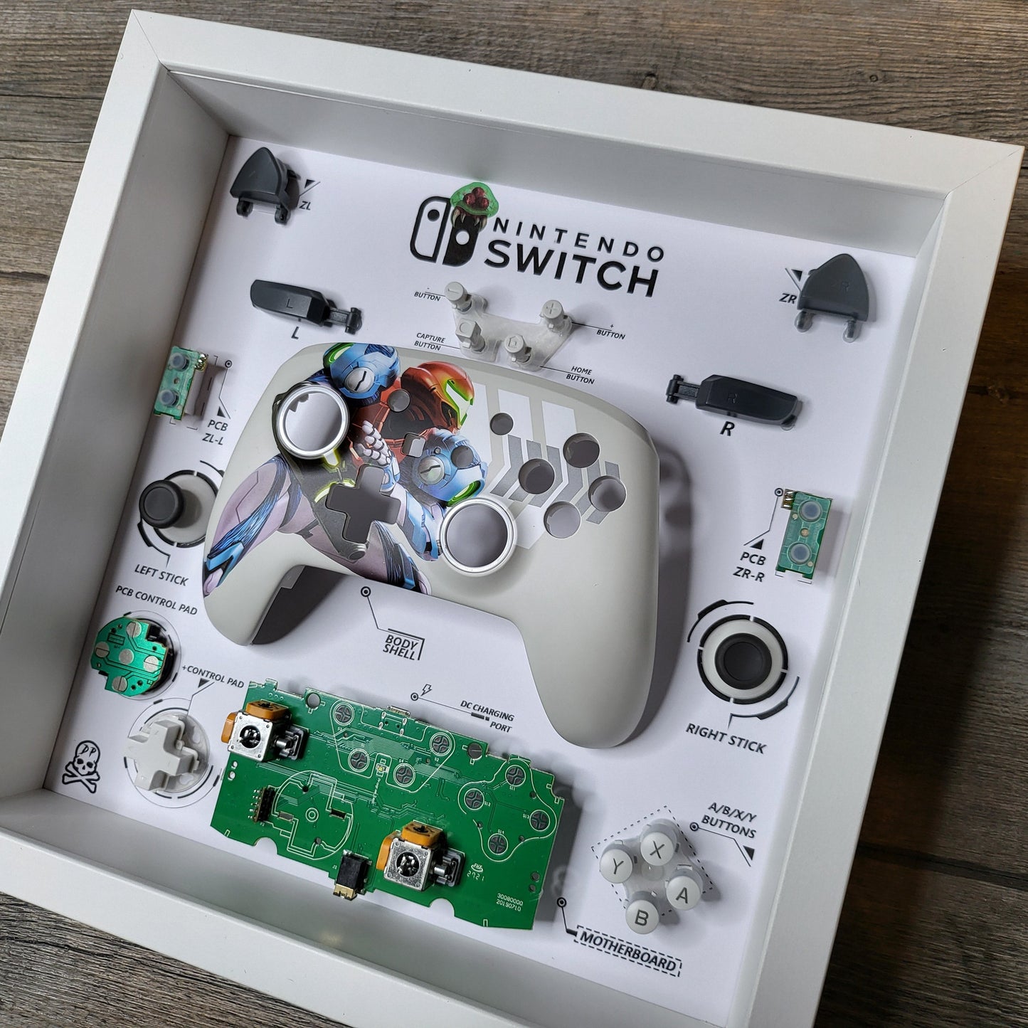 Shadow Box 10x10 with wood frame and polycarbonate glass for wall and Tabletop containing a disassembled controller for Playstation and Nintendo