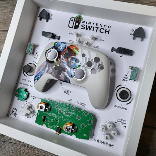 Shadow Box 10x10 with wood frame and polycarbonate glass for wall and Tabletop containing a disassembled controller for Playstation and Nintendo
