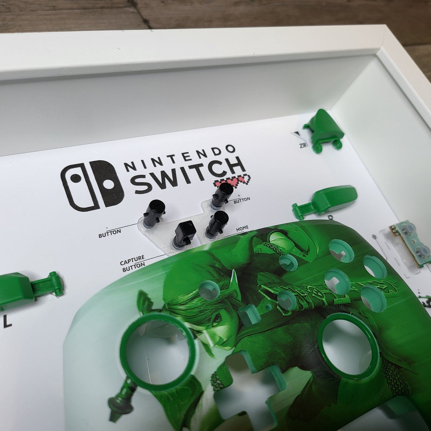 Shadow Box 10x10 with wood frame and polycarbonate glass for wall and Tabletop containing a disassembled controller for Playstation and Nintendo