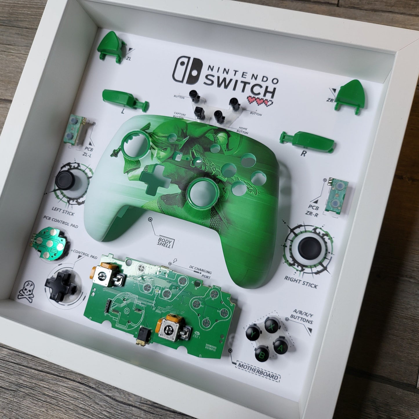 Shadow Box 10x10 with wood frame and polycarbonate glass for wall and Tabletop containing a disassembled controller for Playstation and Nintendo