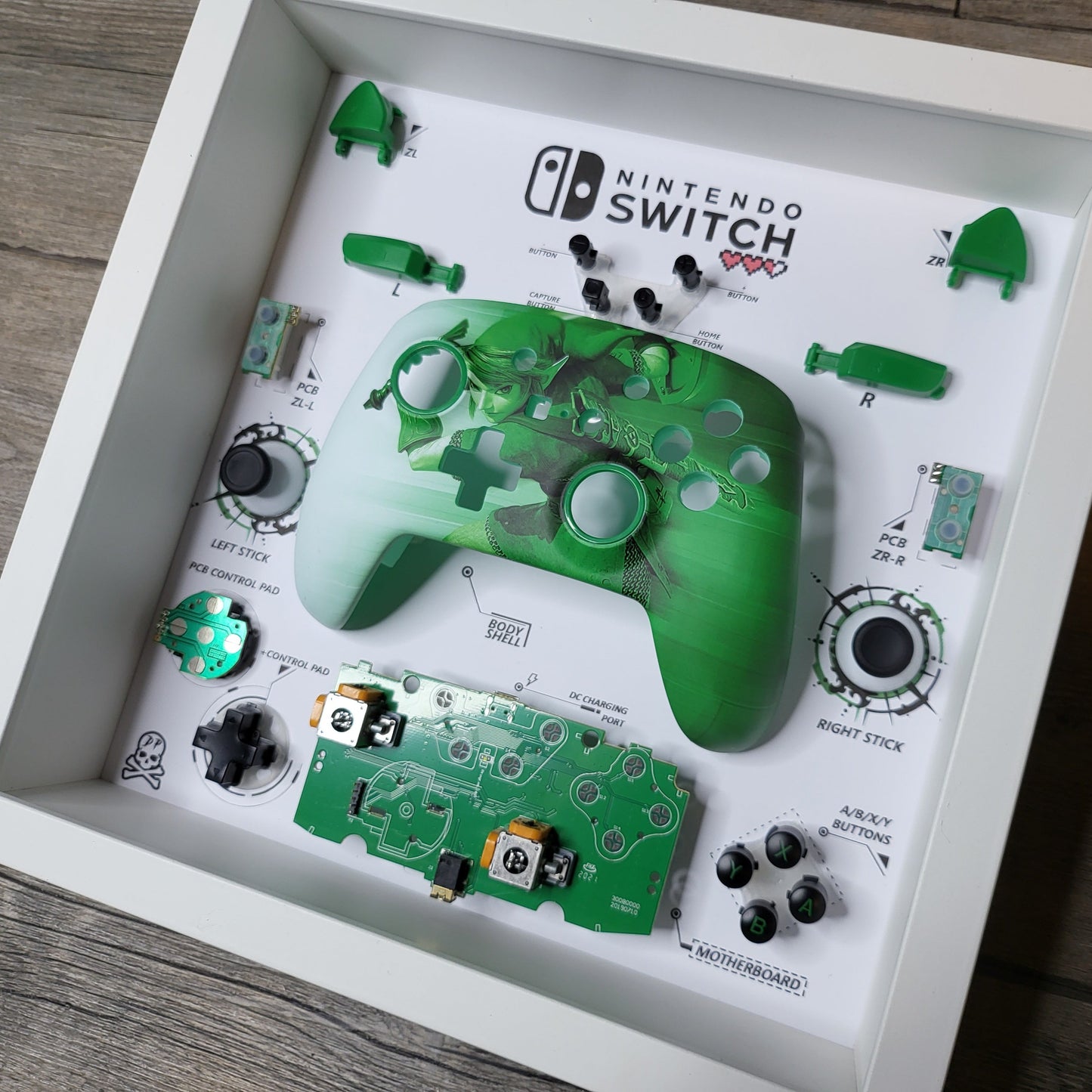 Shadow Box 10x10 with wood frame and polycarbonate glass for wall and Tabletop containing a disassembled controller for Playstation and Nintendo
