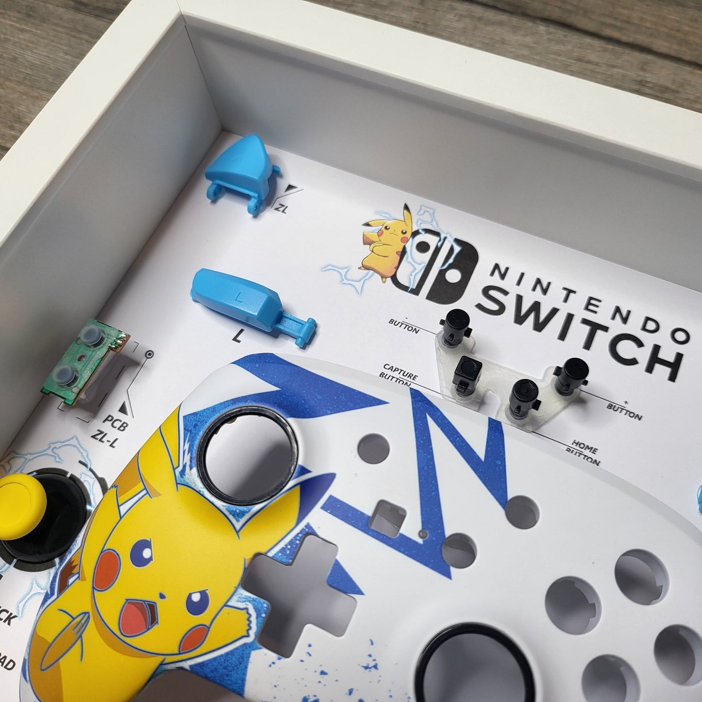 Shadow Box 10x10 with wood frame and polycarbonate glass for wall and Tabletop containing a disassembled controller for Playstation and Nintendo