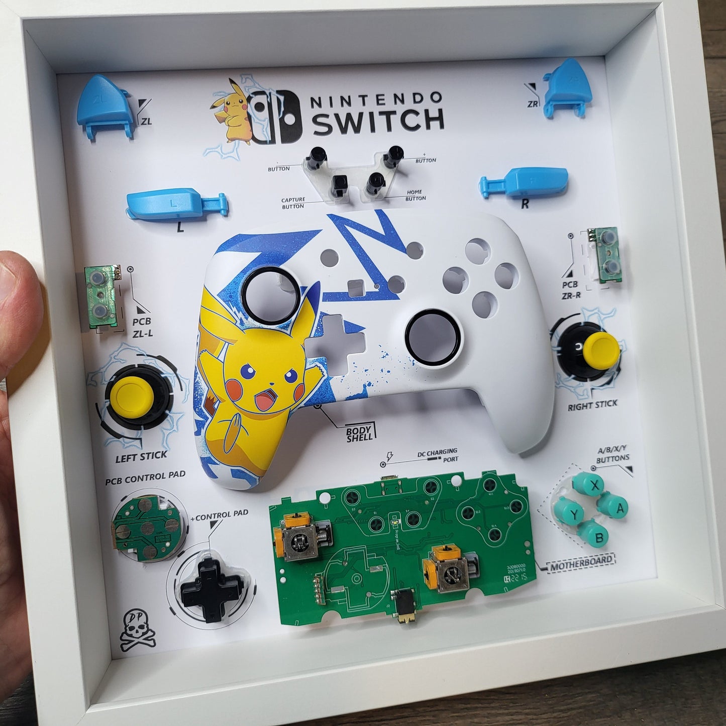 Shadow Box 10x10 with wood frame and polycarbonate glass for wall and Tabletop containing a disassembled controller for Playstation and Nintendo