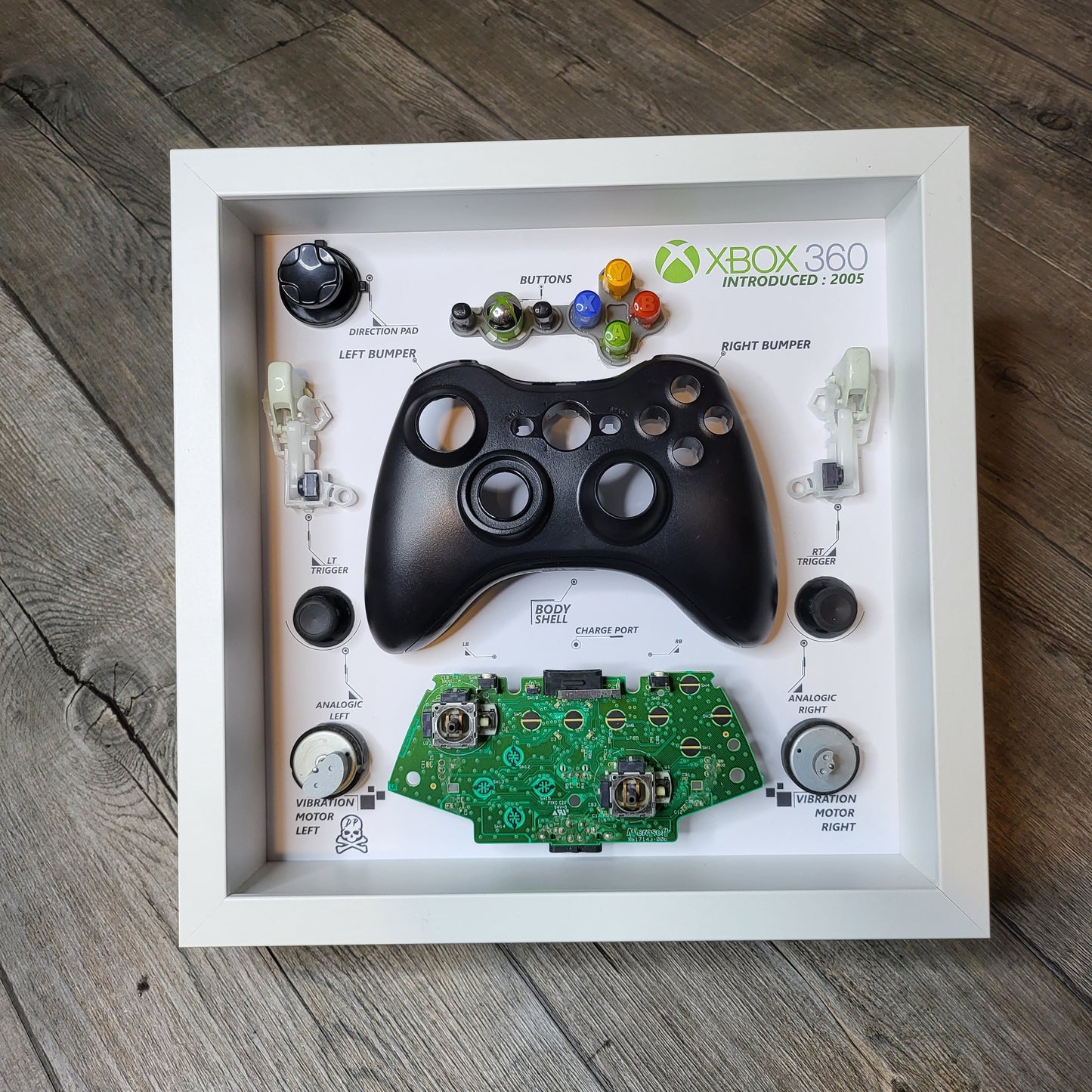Shadow Box 10x10 with wood frame and polycarbonate glass for wall and Tabletop containing a disassembled controller for Playstation and Nintendo