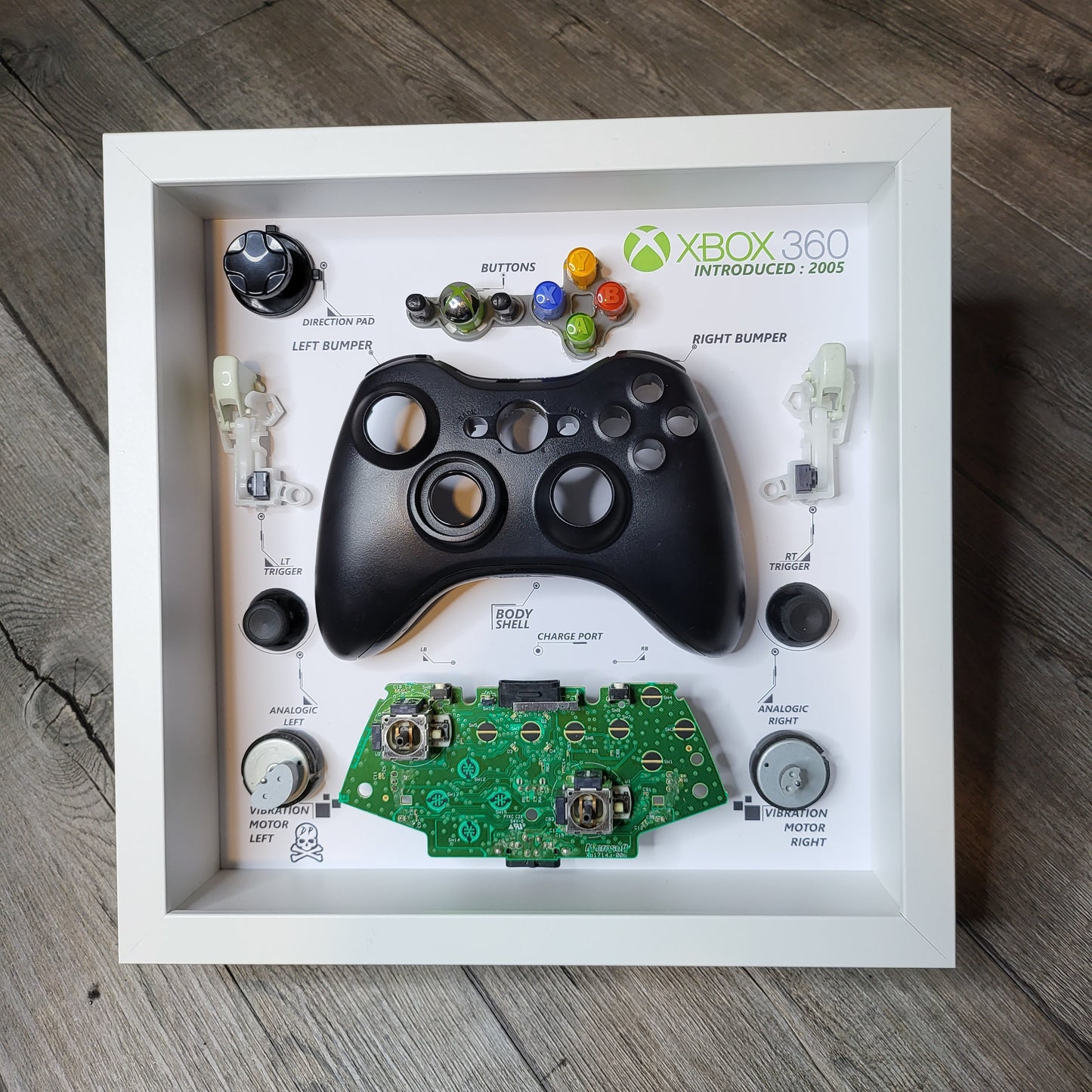 Shadow Box 10x10 with wood frame and polycarbonate glass for wall and Tabletop containing a disassembled controller for Playstation and Nintendo