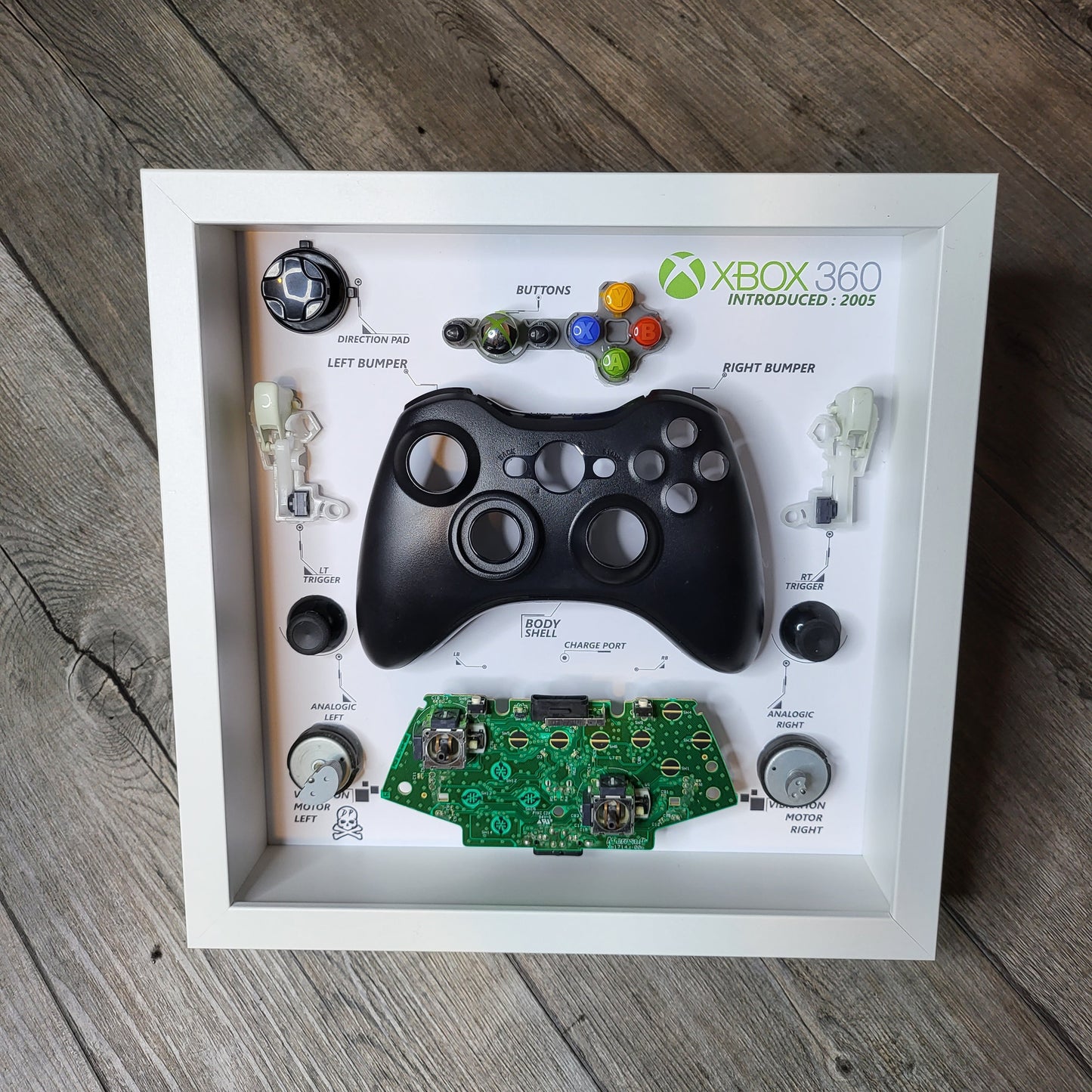 Shadow Box 10x10 with wood frame and polycarbonate glass for wall and Tabletop containing a disassembled controller for Playstation and Nintendo