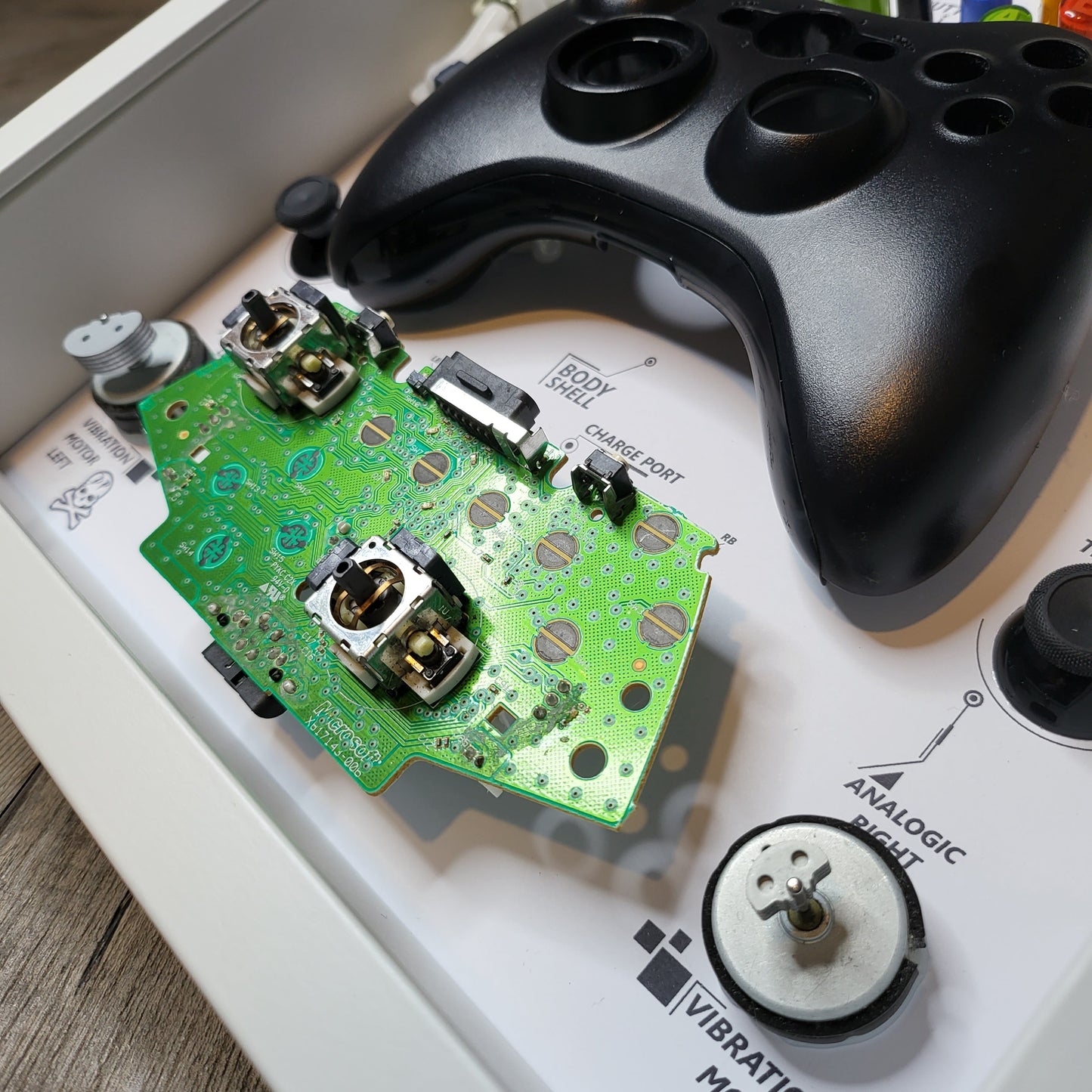 Shadow Box 10x10 with wood frame and polycarbonate glass for wall and Tabletop containing a disassembled controller for Playstation and Nintendo
