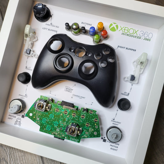 Shadow Box 10x10 with wood frame and polycarbonate glass for wall and Tabletop containing a disassembled controller for Playstation and Nintendo