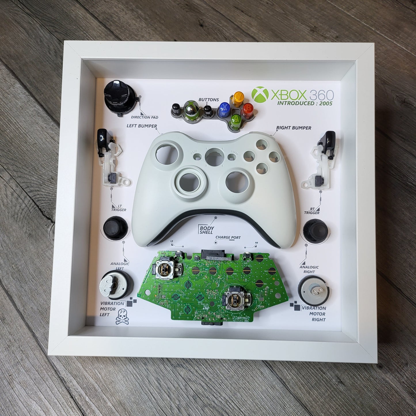 Shadow Box 10x10 with wood frame and polycarbonate glass for wall and Tabletop containing a disassembled controller for Playstation and Nintendo