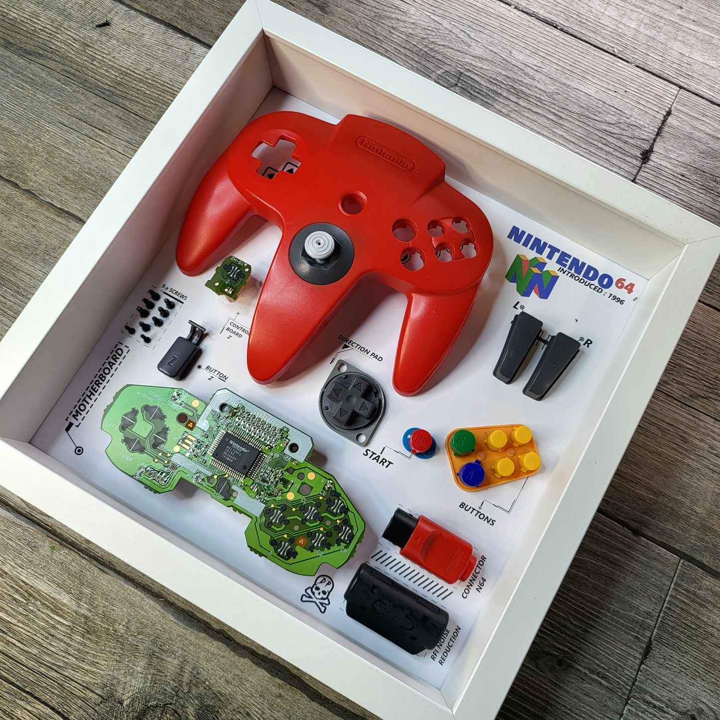 Shadow Box 10x10 with wood frame and polycarbonate glass for wall and Tabletop containing a disassembled controller for Playstation and Nintendo
