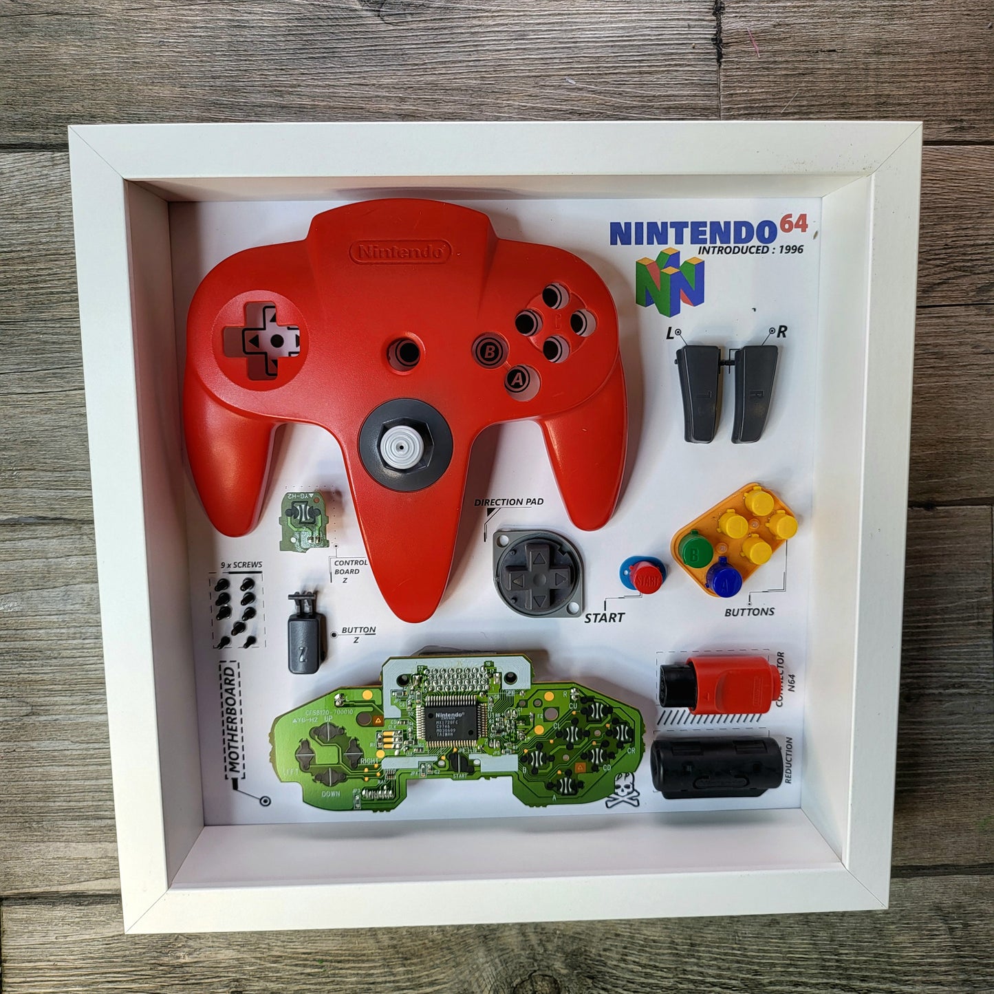 Shadow Box 10x10 with wood frame and polycarbonate glass for wall and Tabletop containing a disassembled controller for Playstation and Nintendo