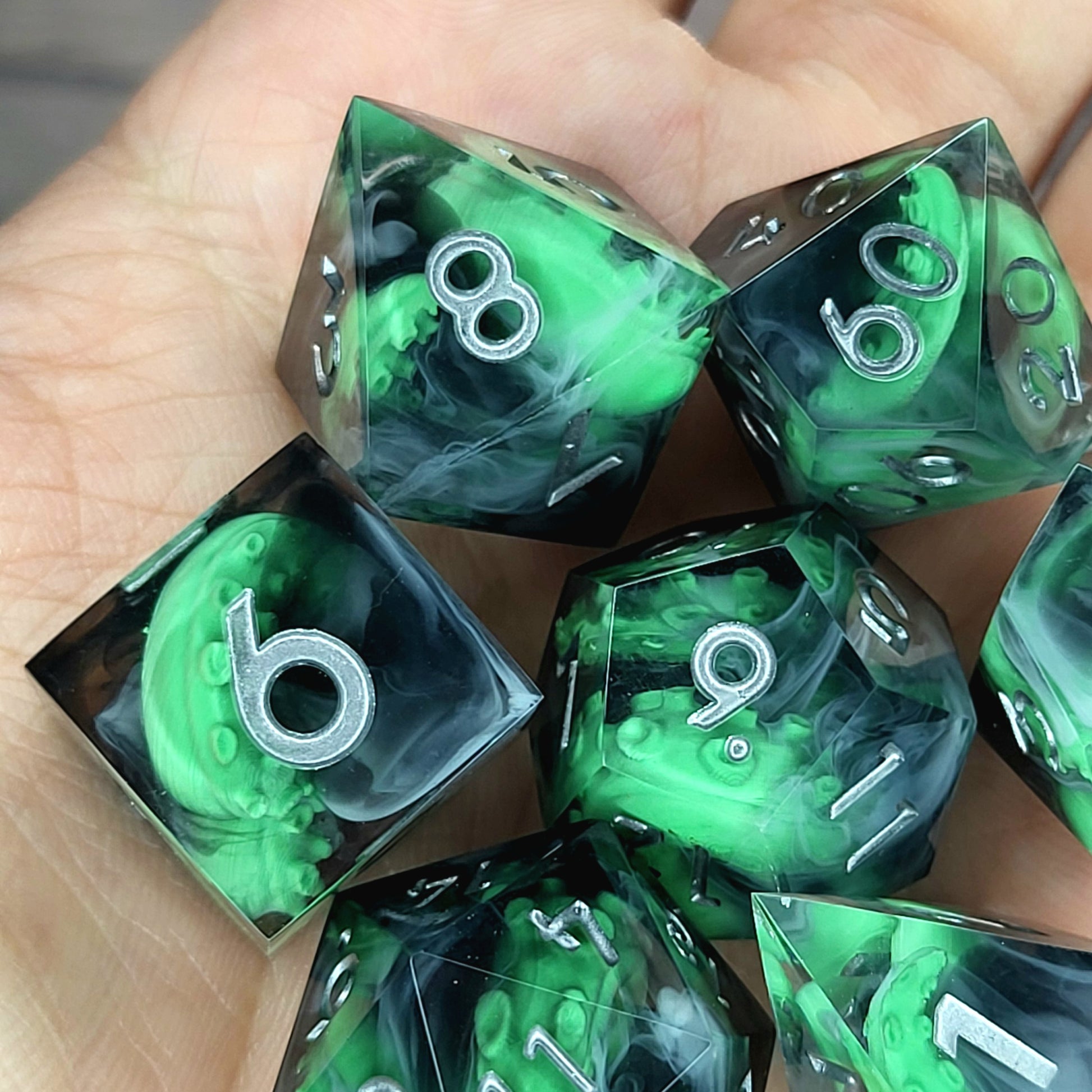 Call of Cthulhu Inspired Tentacle Dice Set
Handcrafted sharp edge resin dice featuring eerie green tentacles suspended in dark transparent resin, surrounded by ghostly white mist and finished with metallic silver numbers