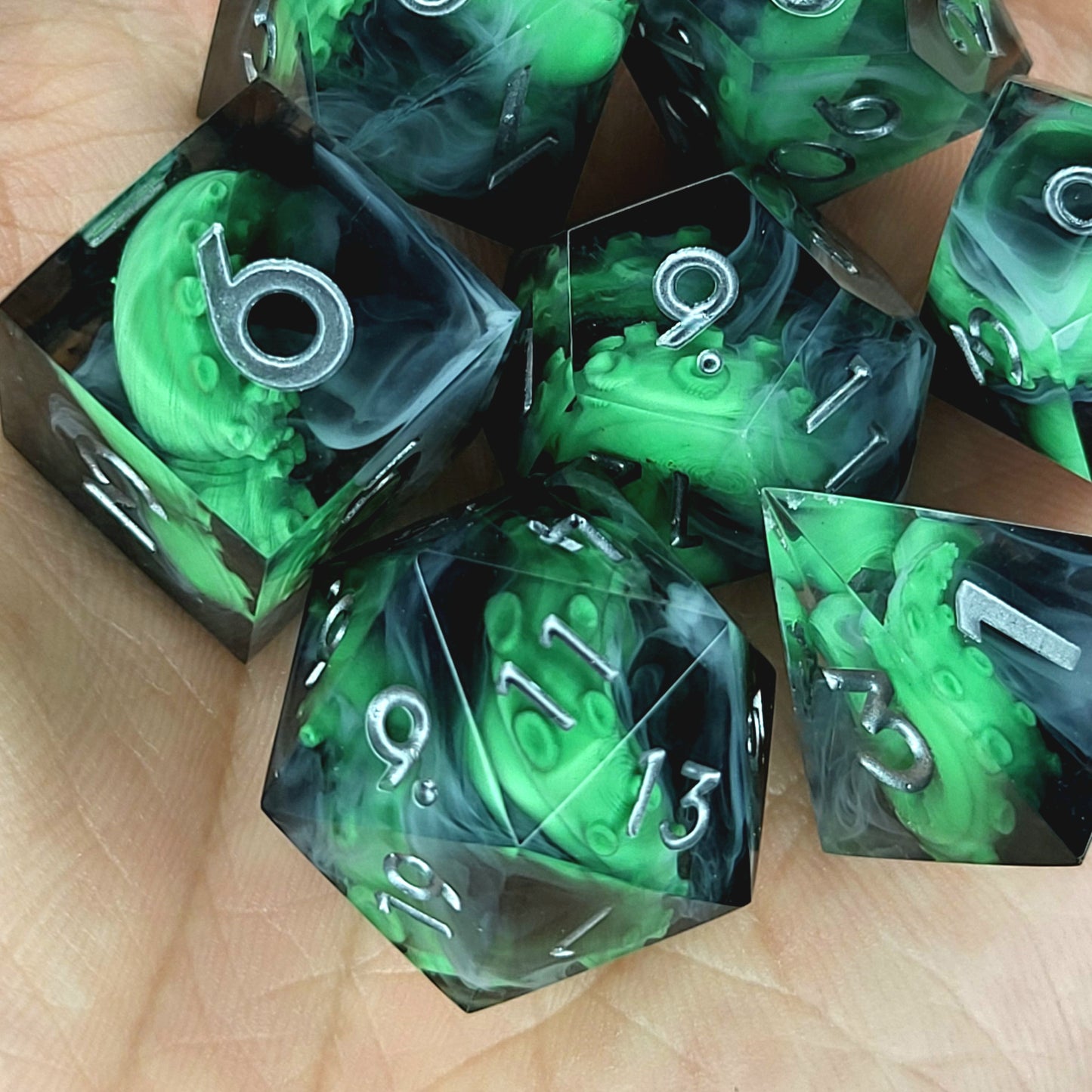 Call of Cthulhu Inspired Tentacle Dice Set
Handcrafted sharp edge resin dice featuring eerie green tentacles suspended in dark transparent resin, surrounded by ghostly white mist and finished with metallic silver numbers