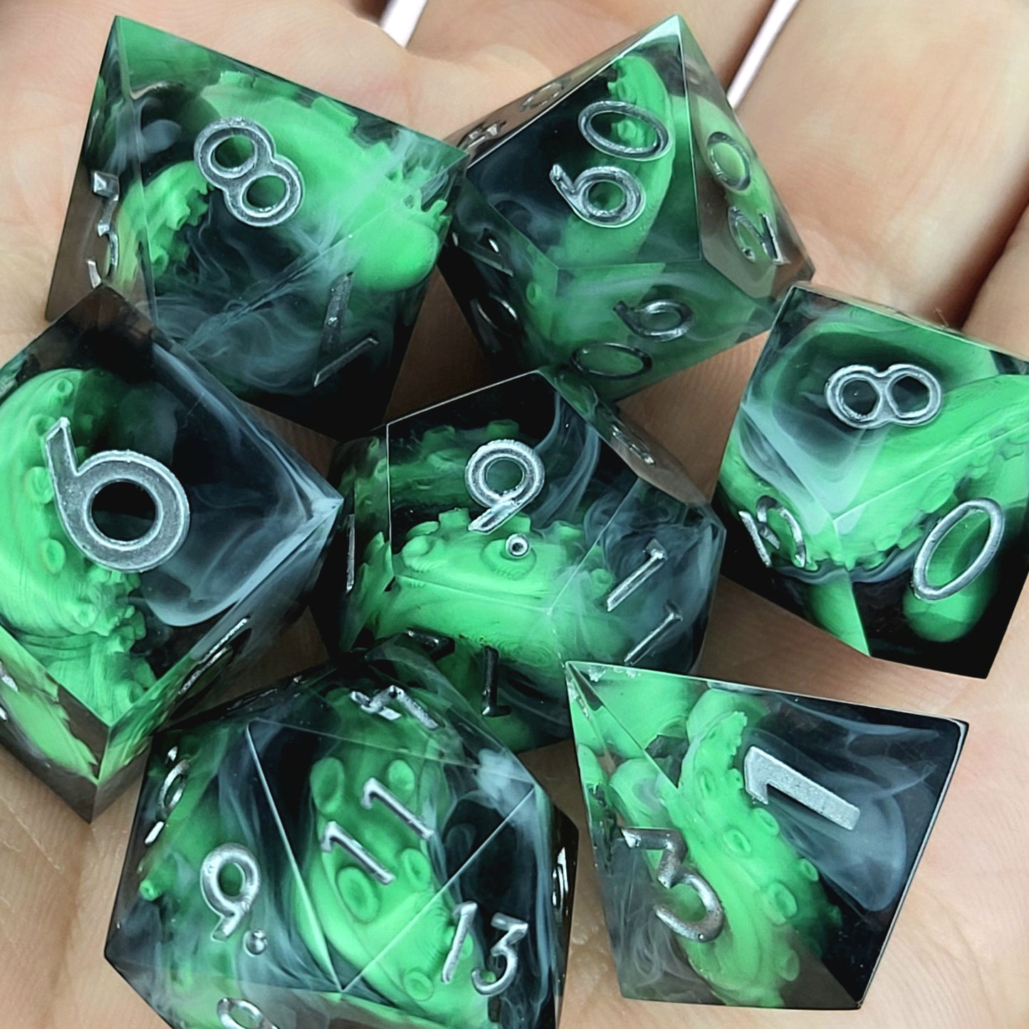 Call of Cthulhu Inspired Tentacle Dice Set
Handcrafted sharp edge resin dice featuring eerie green tentacles suspended in dark transparent resin, surrounded by ghostly white mist and finished with metallic silver numbers