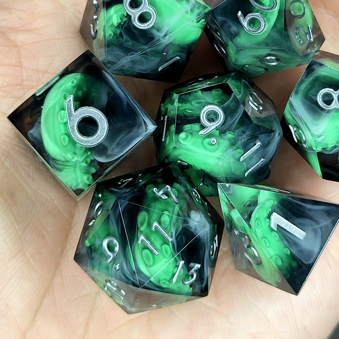 Call of Cthulhu Inspired Tentacle Dice Set
Handcrafted sharp edge resin dice featuring eerie green tentacles suspended in dark transparent resin, surrounded by ghostly white mist and finished with metallic silver numbers