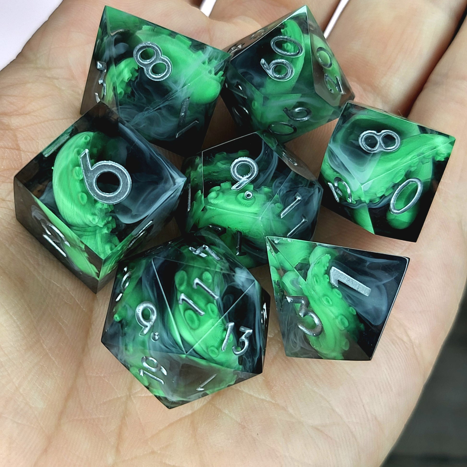 Call of Cthulhu Inspired Tentacle Dice Set
Handcrafted sharp edge resin dice featuring eerie green tentacles suspended in dark transparent resin, surrounded by ghostly white mist and finished with metallic silver numbers