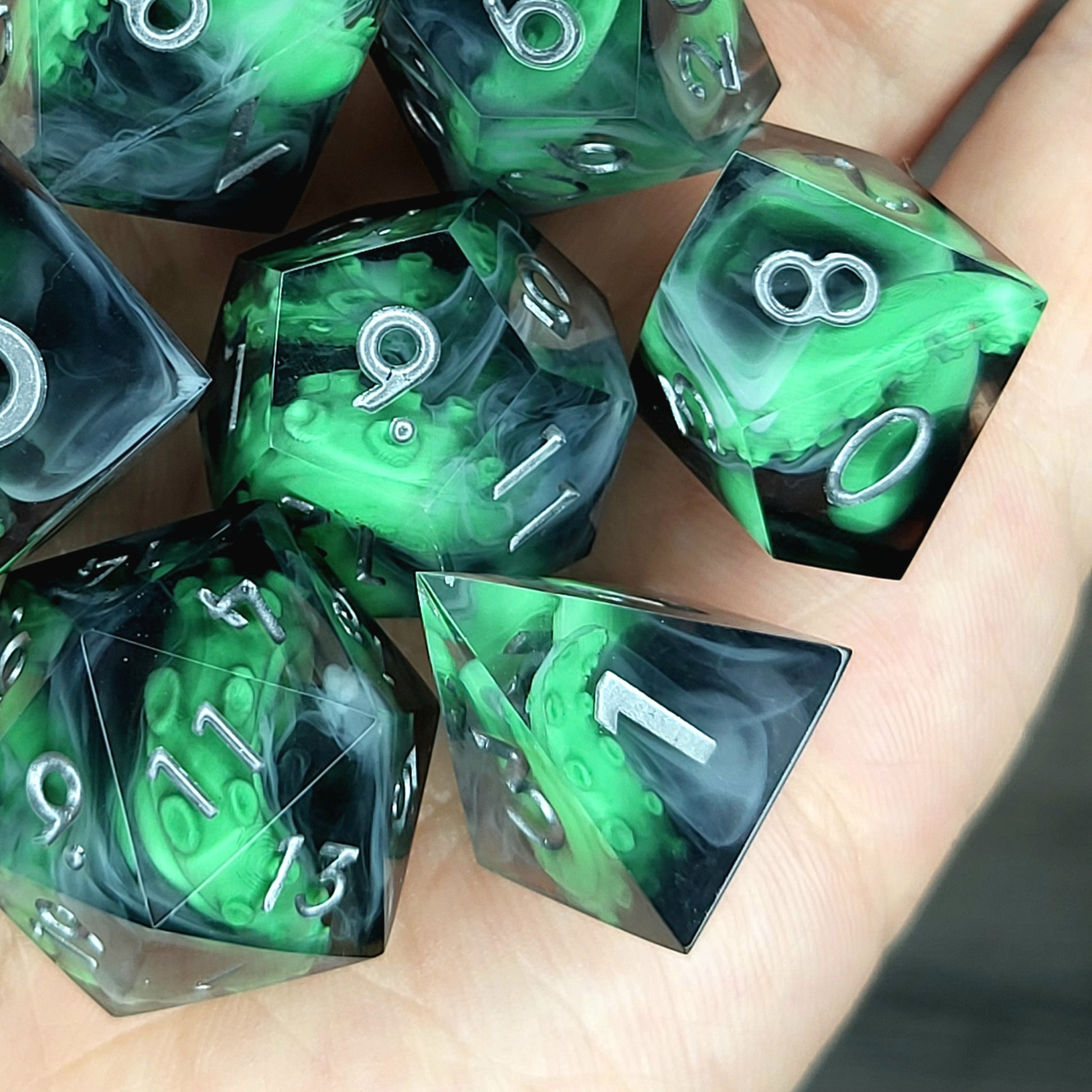 Call of Cthulhu Inspired Tentacle Dice Set
Handcrafted sharp edge resin dice featuring eerie green tentacles suspended in dark transparent resin, surrounded by ghostly white mist and finished with metallic silver numbers