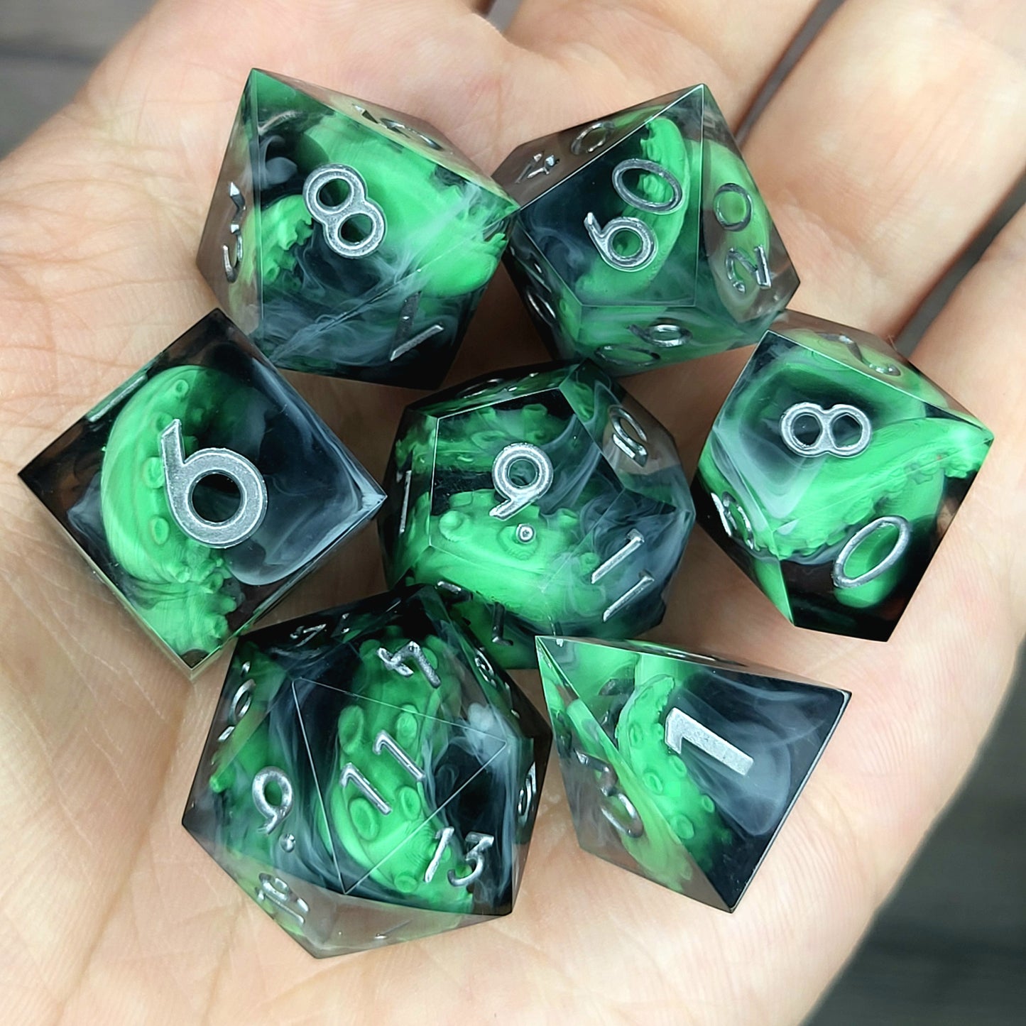 Call of Cthulhu Inspired Tentacle Dice Set
Handcrafted sharp edge resin dice featuring eerie green tentacles suspended in dark transparent resin, surrounded by ghostly white mist and finished with metallic silver numbers