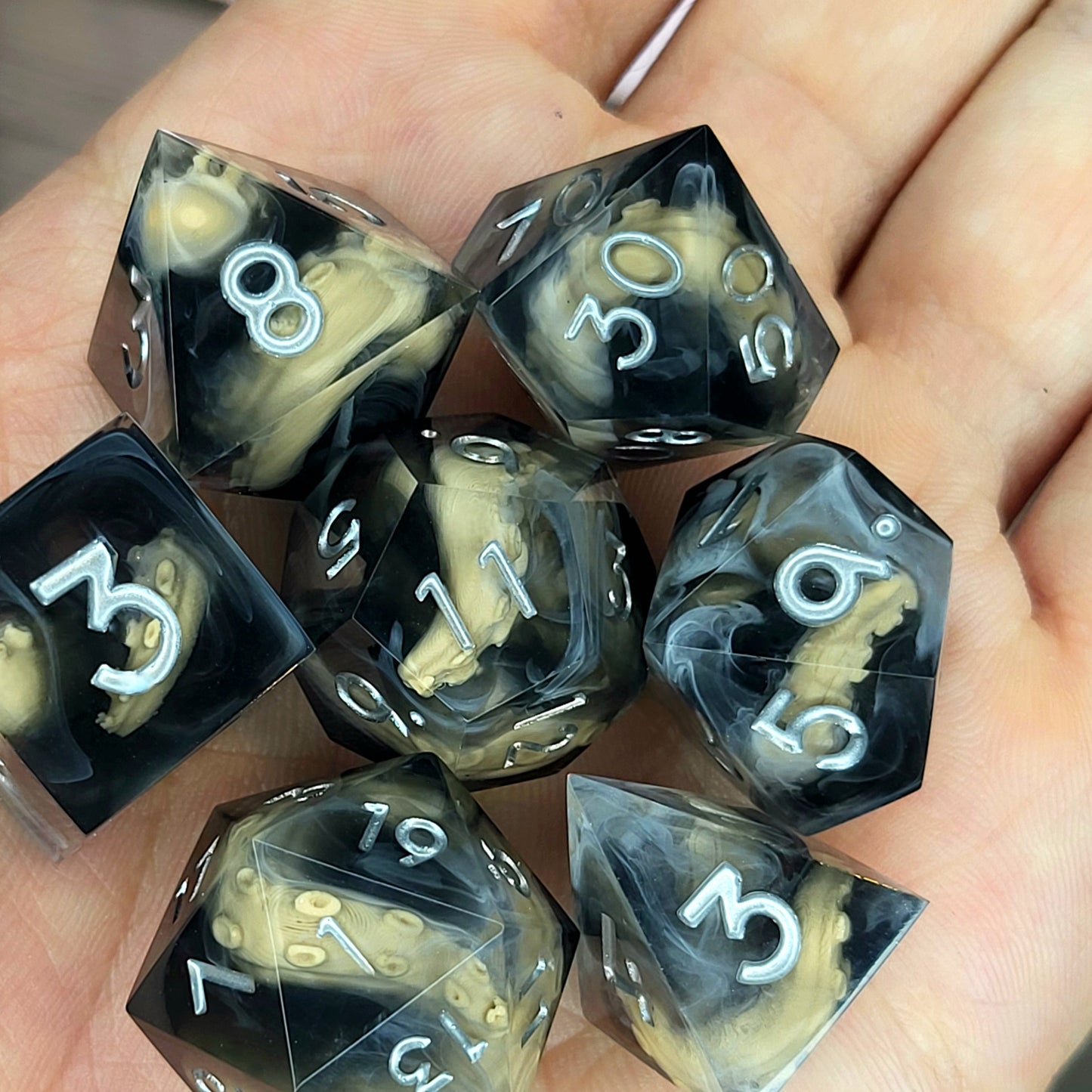 Handcrafted sharp edge resin dice featuring eerie brown tentacles suspended in dark transparent resin, surrounded by ghostly white mist and finished with metallic silver numbers