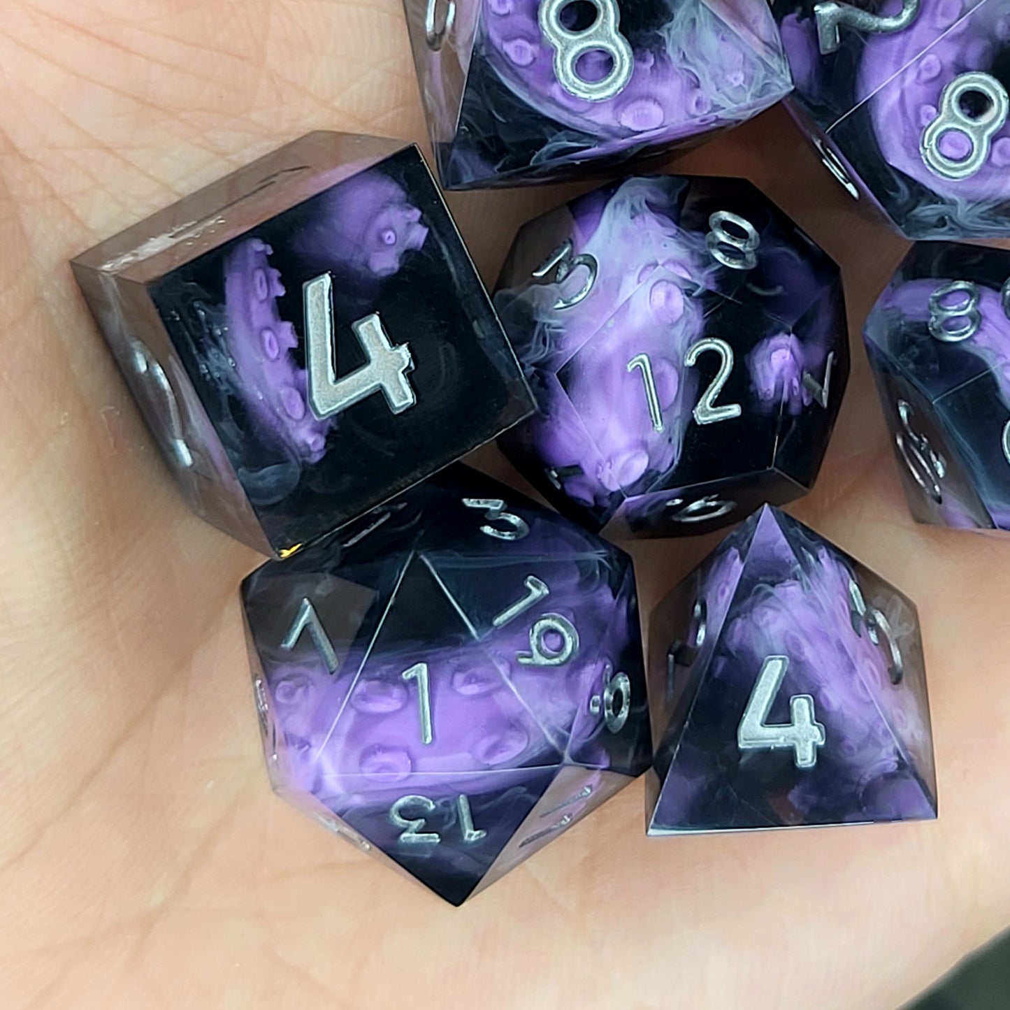 Handcrafted sharp edge resin dice featuring eerie purple tentacles suspended in dark transparent resin, surrounded by ghostly white mist and finished with metallic silver numbers