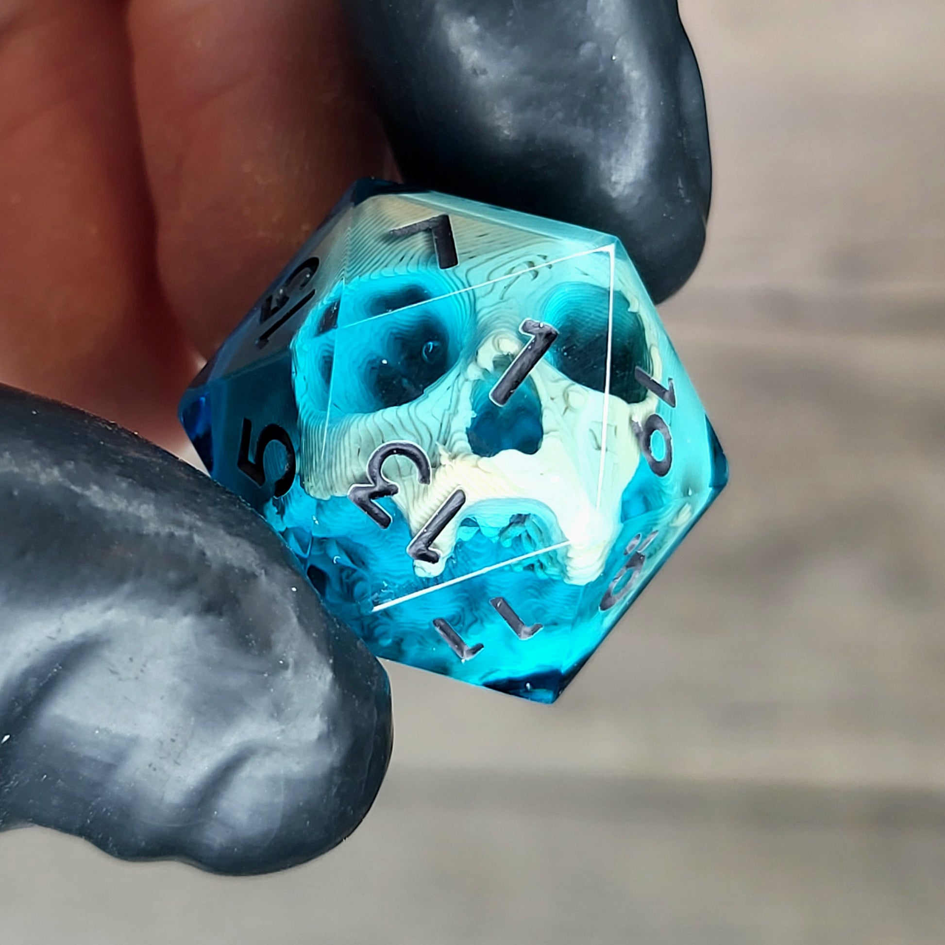 This is a single set of one D20 die with a light brown skull inside , blue resin and black numbers for play dnd dungeons and dragons