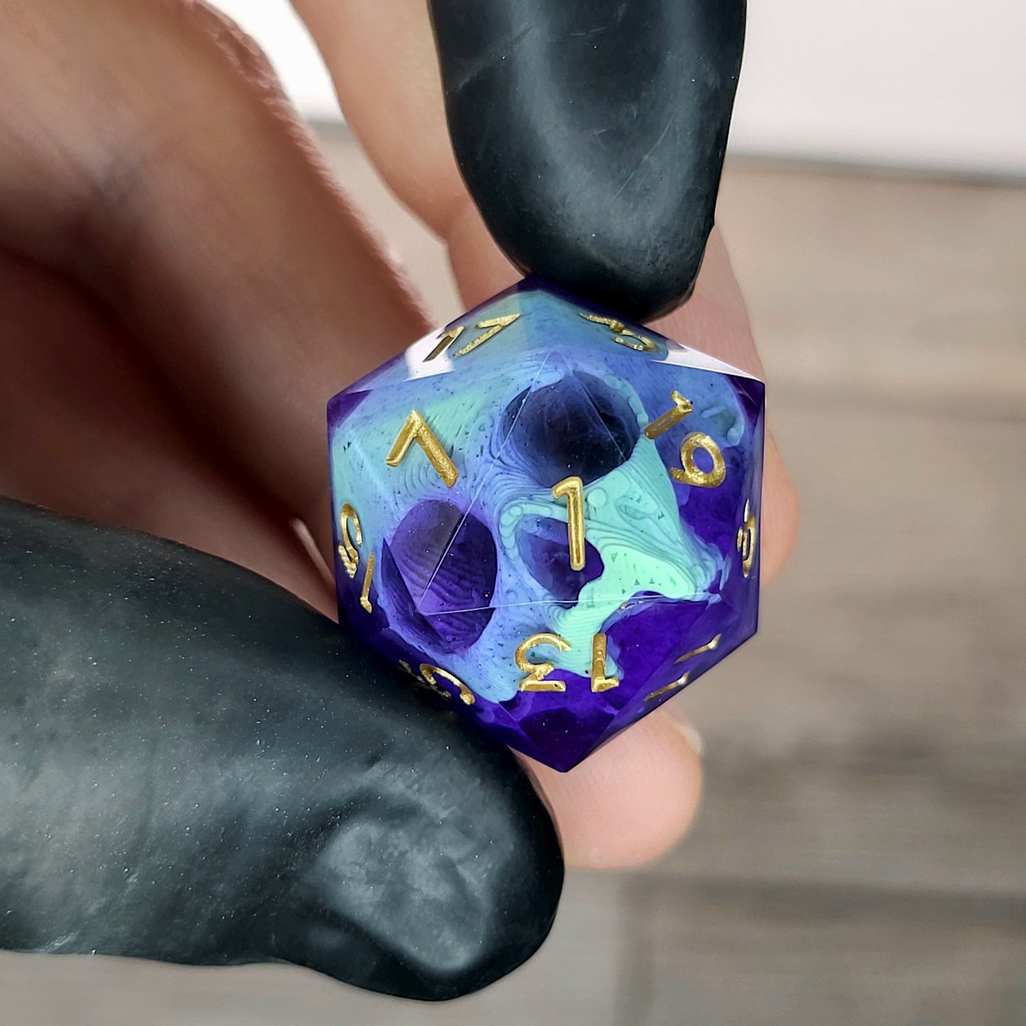 This is a single set of one D20 DnD die with a light green skull inside , purple resin and gold numbers