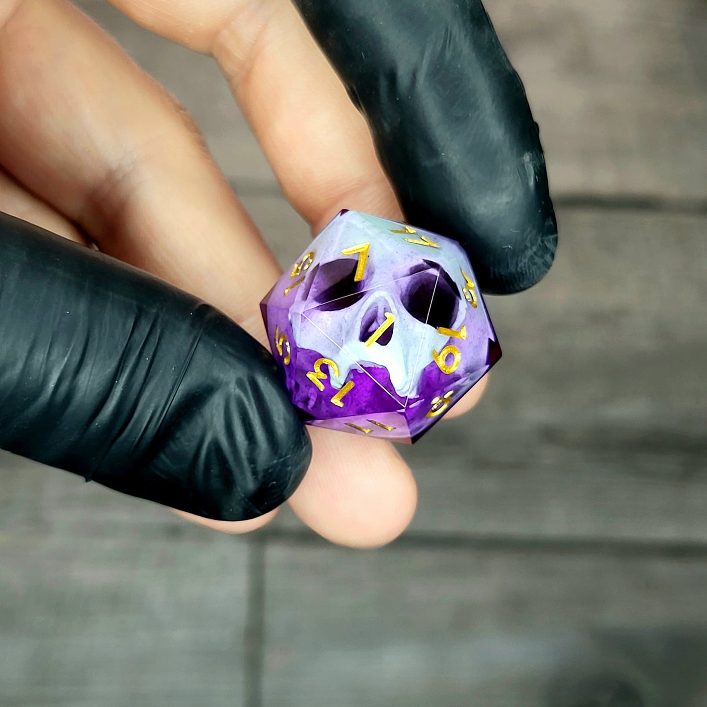This is a single set of one D20 DnD die with a light green skull inside , purple resin and gold numbers