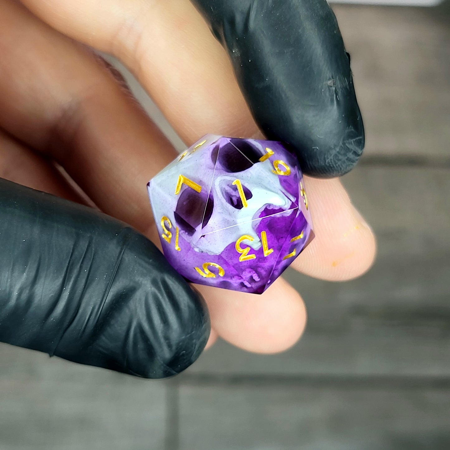 This is a single set of one D20 DnD die with a light green skull inside , purple resin and gold numbers