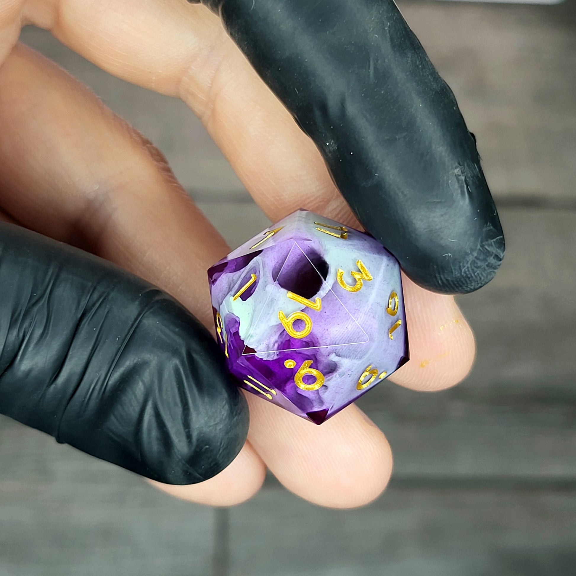 This is a single set of one D20 DnD die with a light green skull inside , purple resin and gold numbers