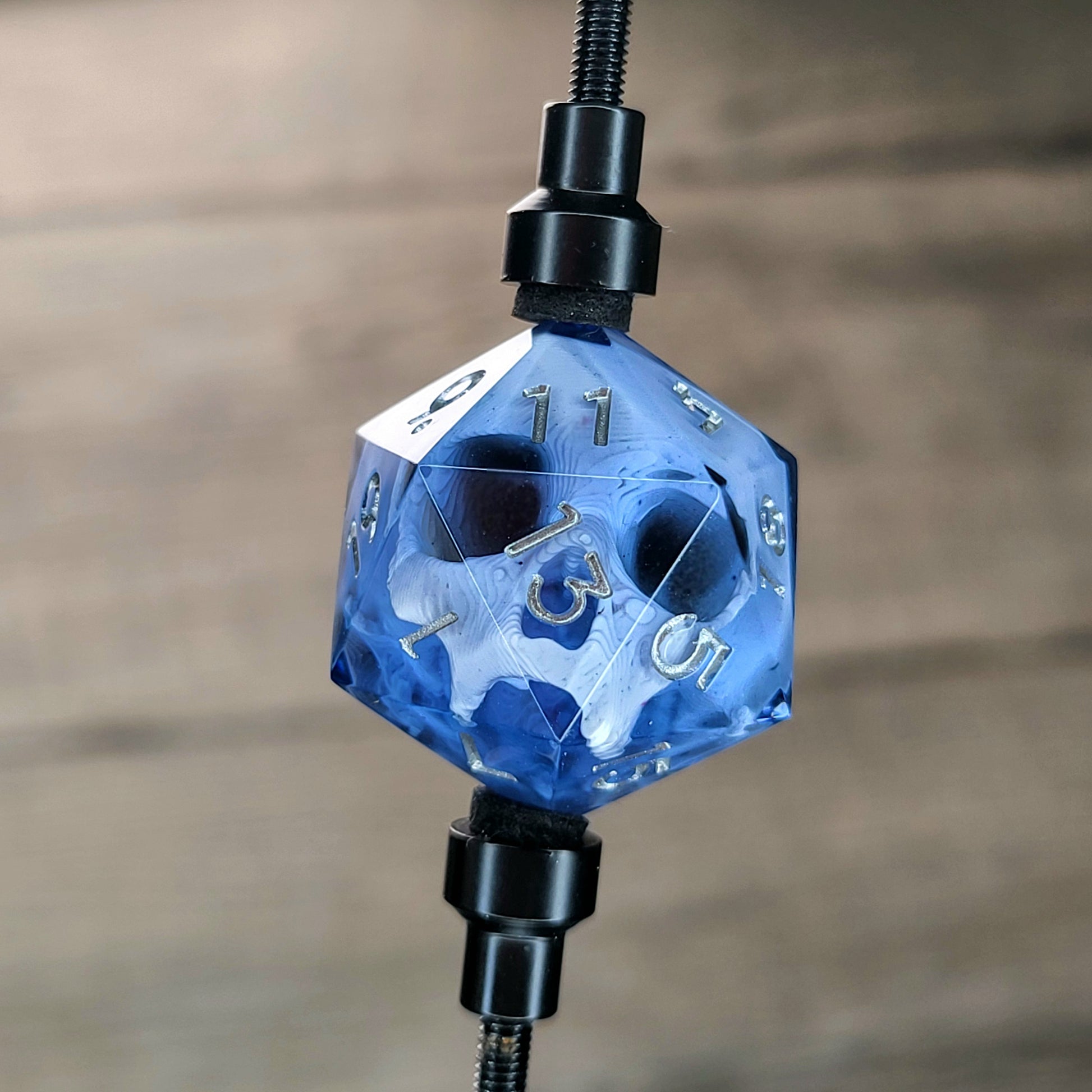 This is a single set of one D20 DnD die with a white skull inside , black resin and silver numbers