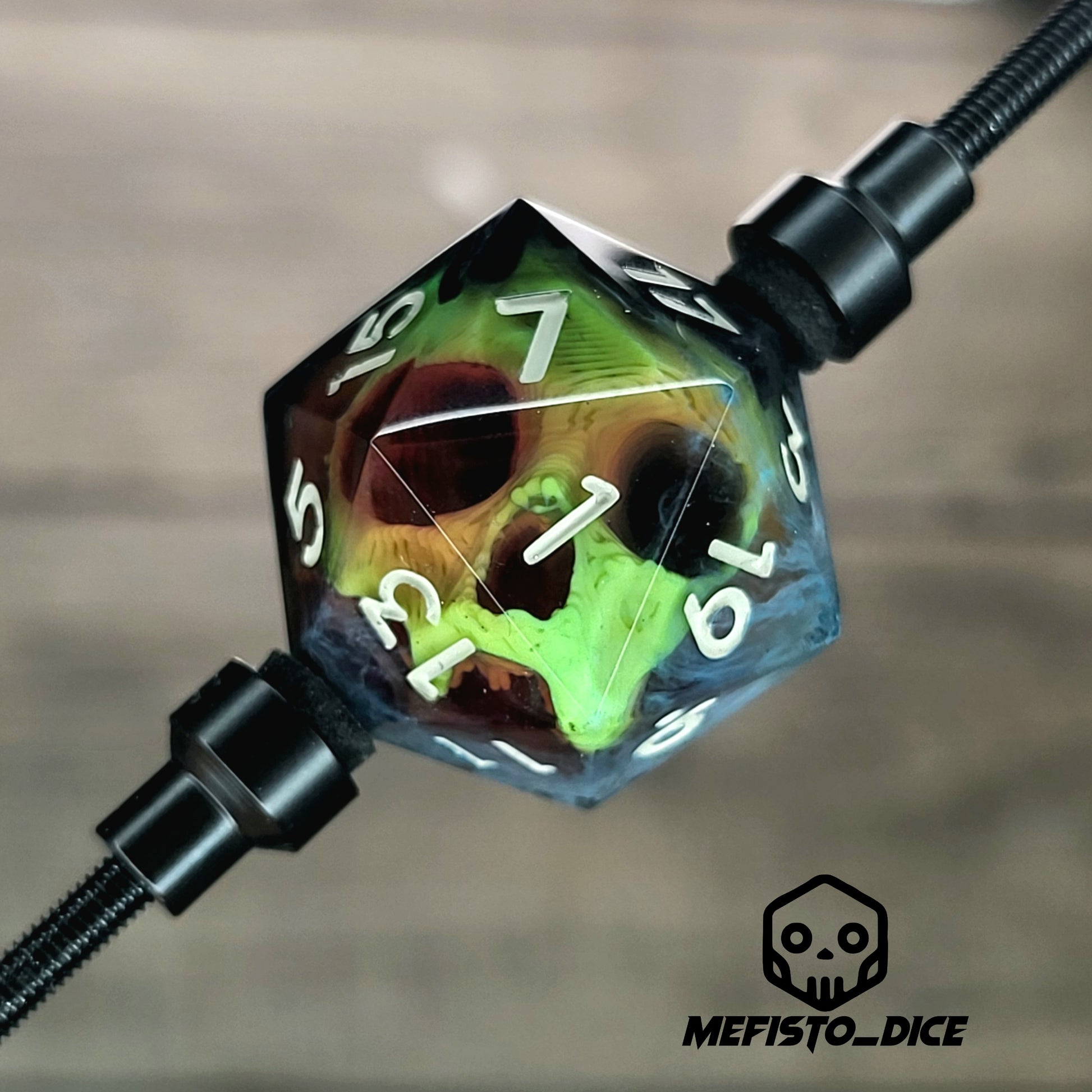 This is a single set of one D20 DnD die with a yellow skull inside , black and white resin and gold and grey number