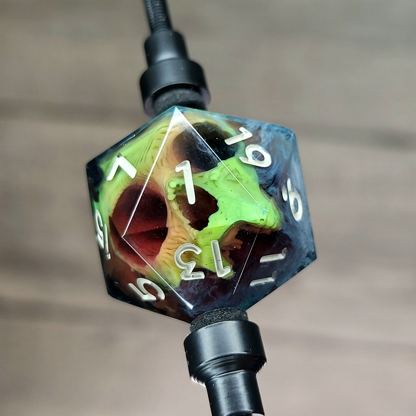 This is a single set of one D20 DnD die with a yellow skull inside , black and white resin and gold and grey number