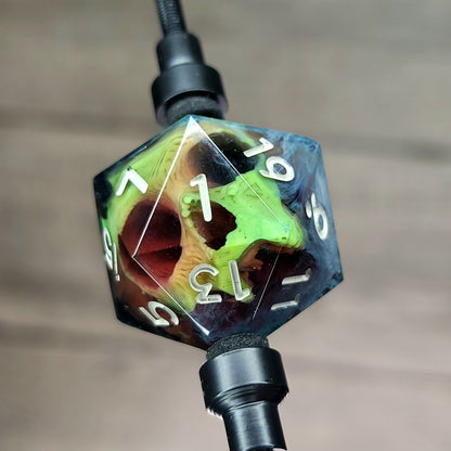 This is a single set of one D20 DnD die with a yellow skull inside , black and white resin and gold and grey number