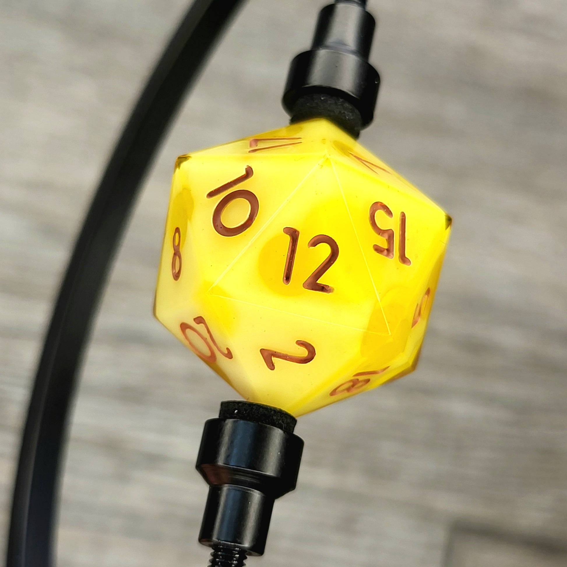 This is a single set of one D20 DnD die with a yellow cheese inside , brown numbers