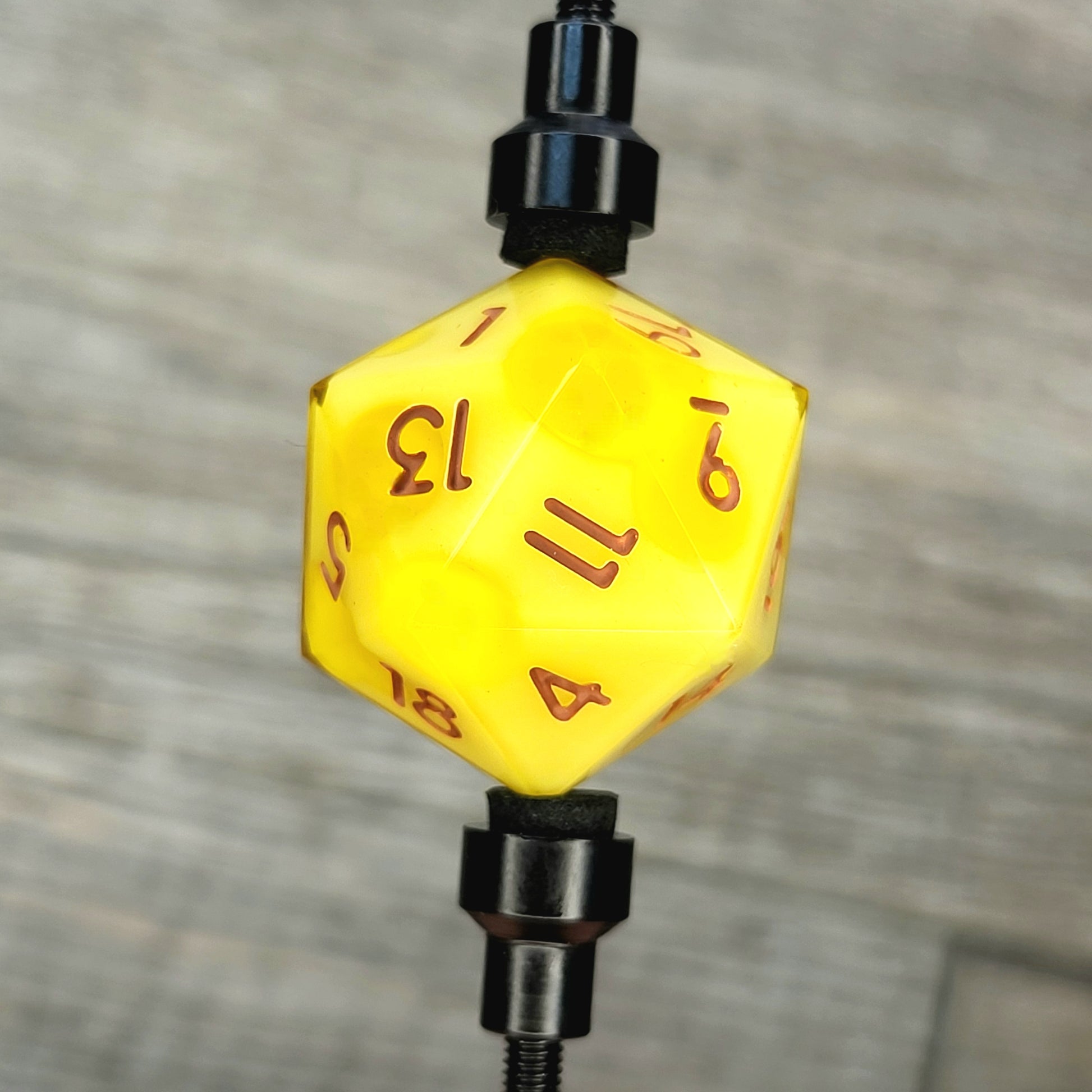 This is a single set of one D20 DnD die with a yellow cheese inside , brown numbers