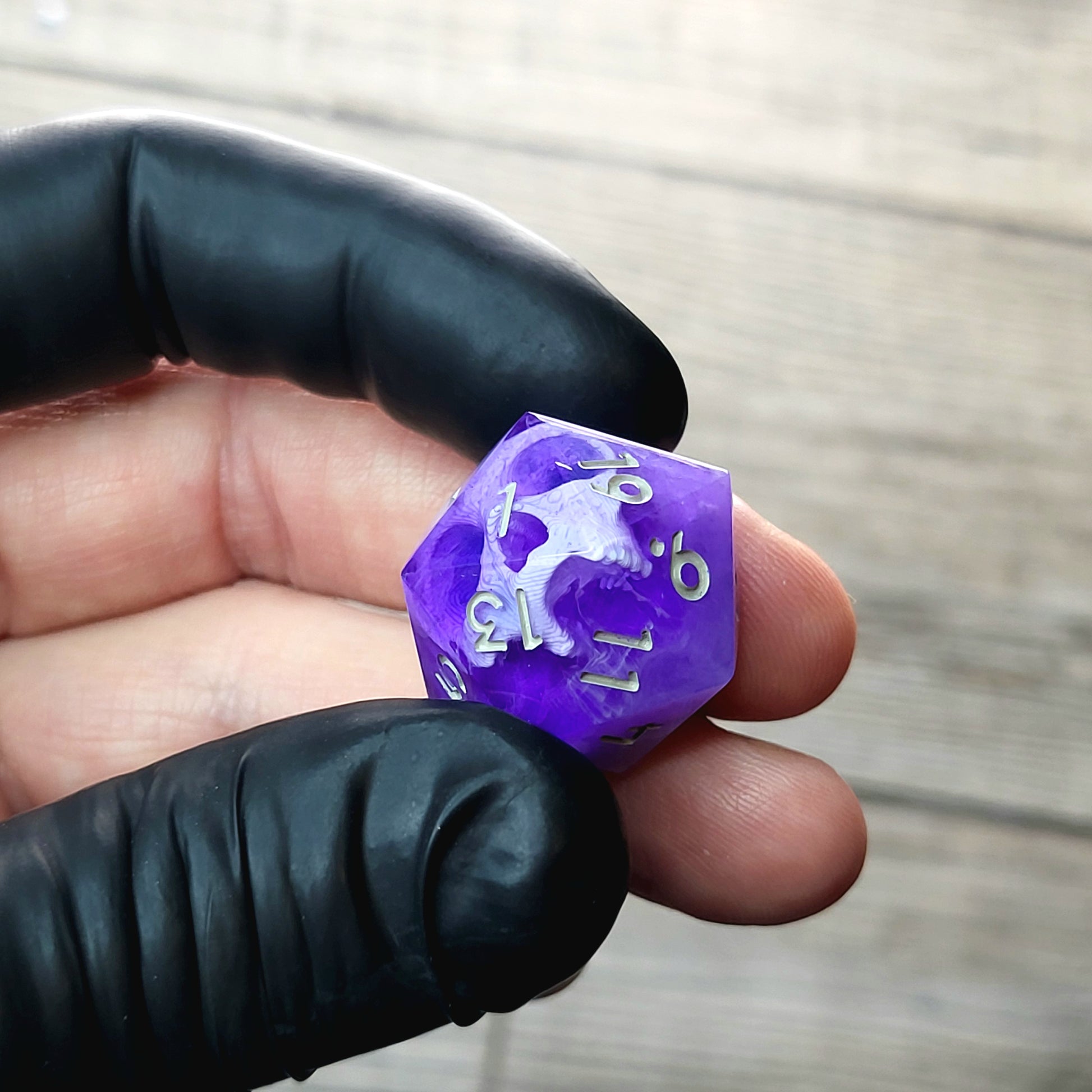 This is a single set of one D20 DnD die with a white skull inside , purple resin and grey numbers