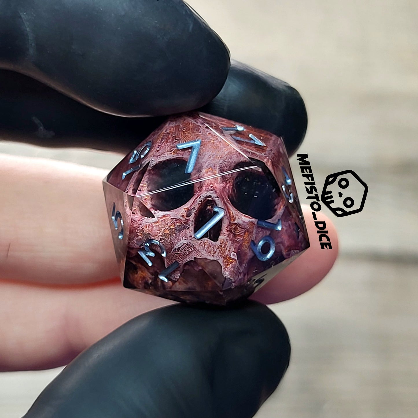 This is a single set of one D20 DnD die with a bronze skull inside , black resin and silver numbers