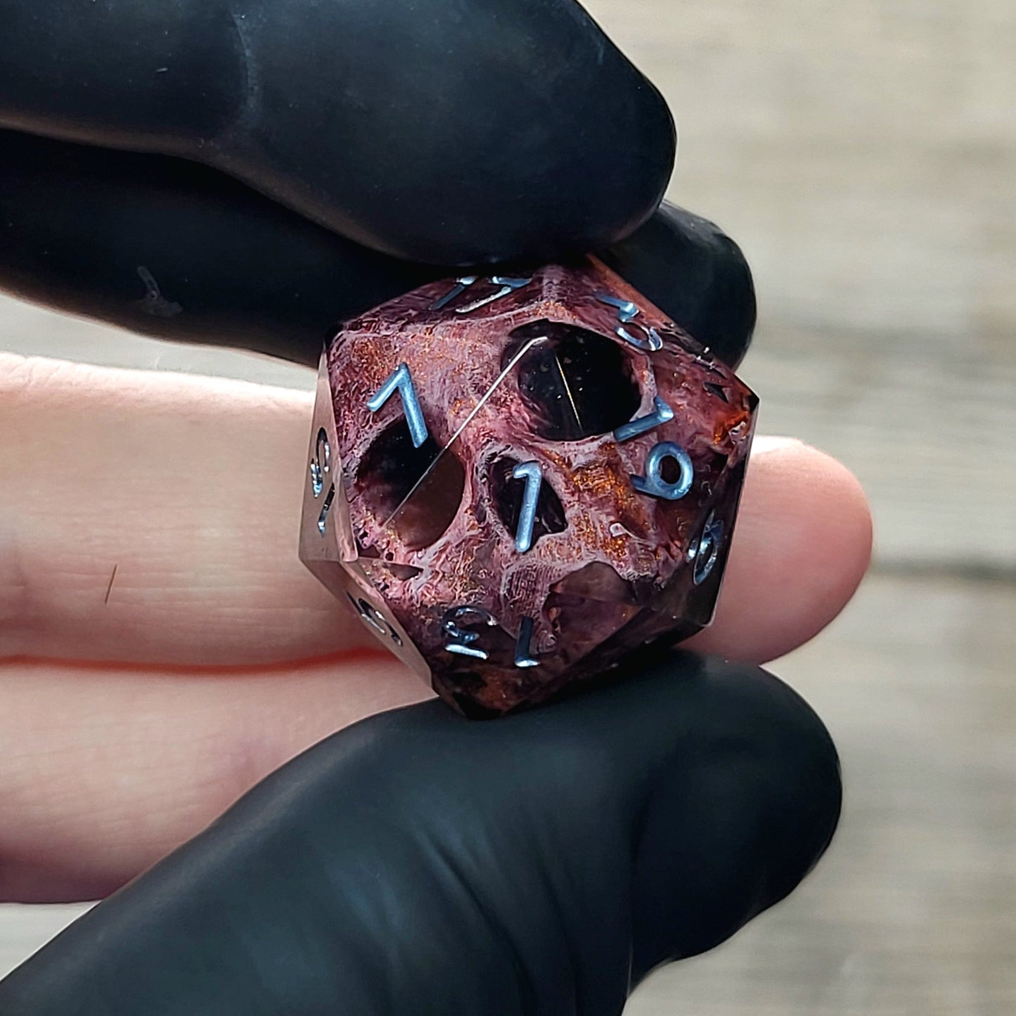 This is a single set of one D20 DnD die with a bronze skull inside , black resin and silver numbers